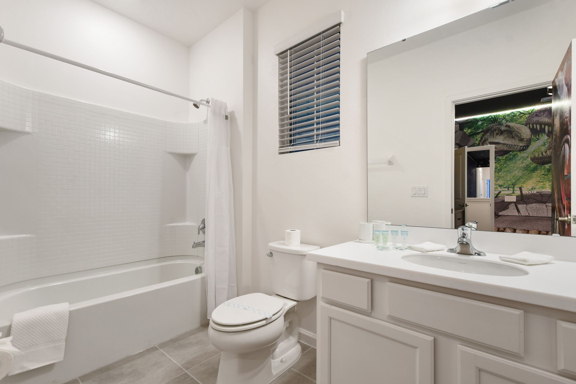 Jungle-themed family bathroom with modern fixtures and fun dinosaur decor.
