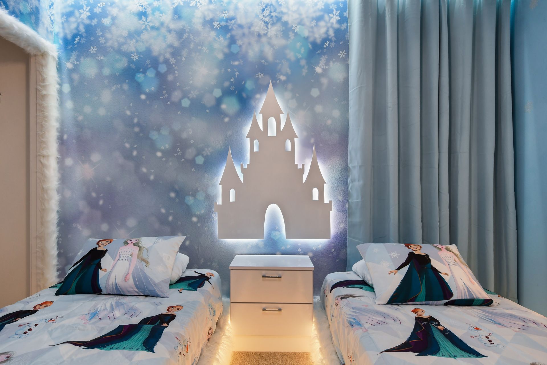 Frozen-themed bedroom with glowing beds, snowflake lights, and magical castle mural
