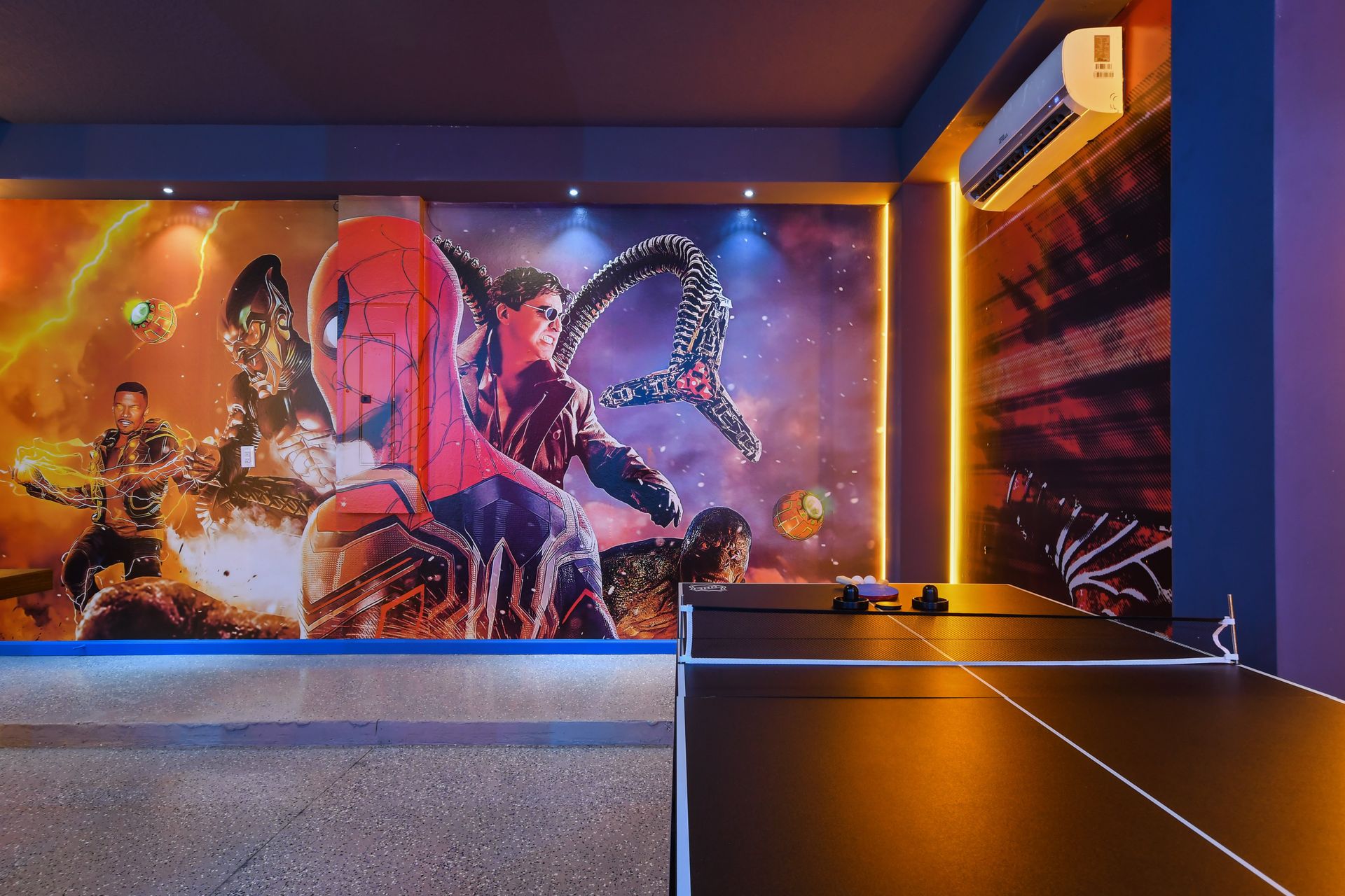 Vibrant Spider-Man themed game room with action-packed murals and air hockey table
