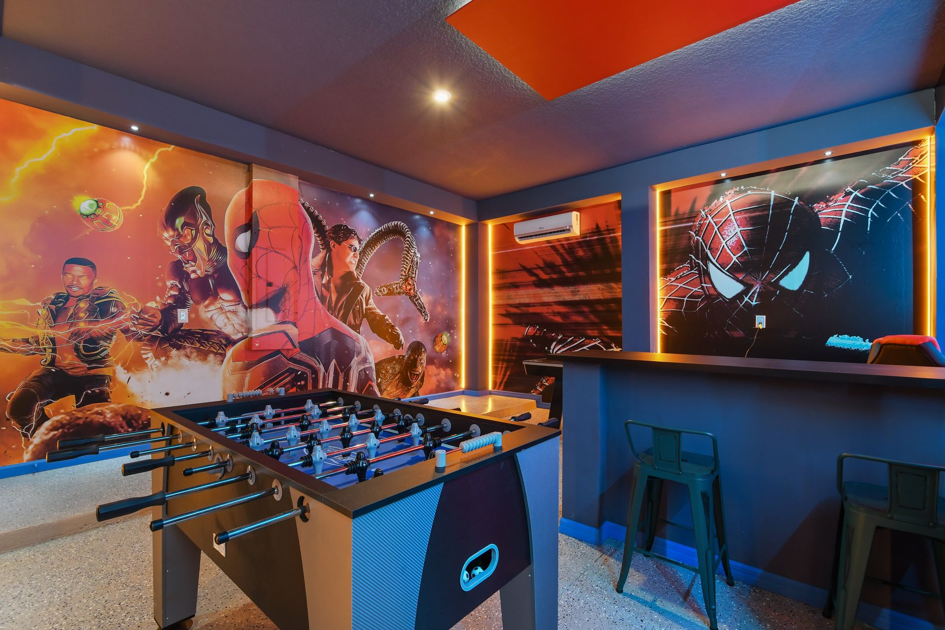 Vibrant Spider-Man themed game room with action-packed murals and air hockey table
