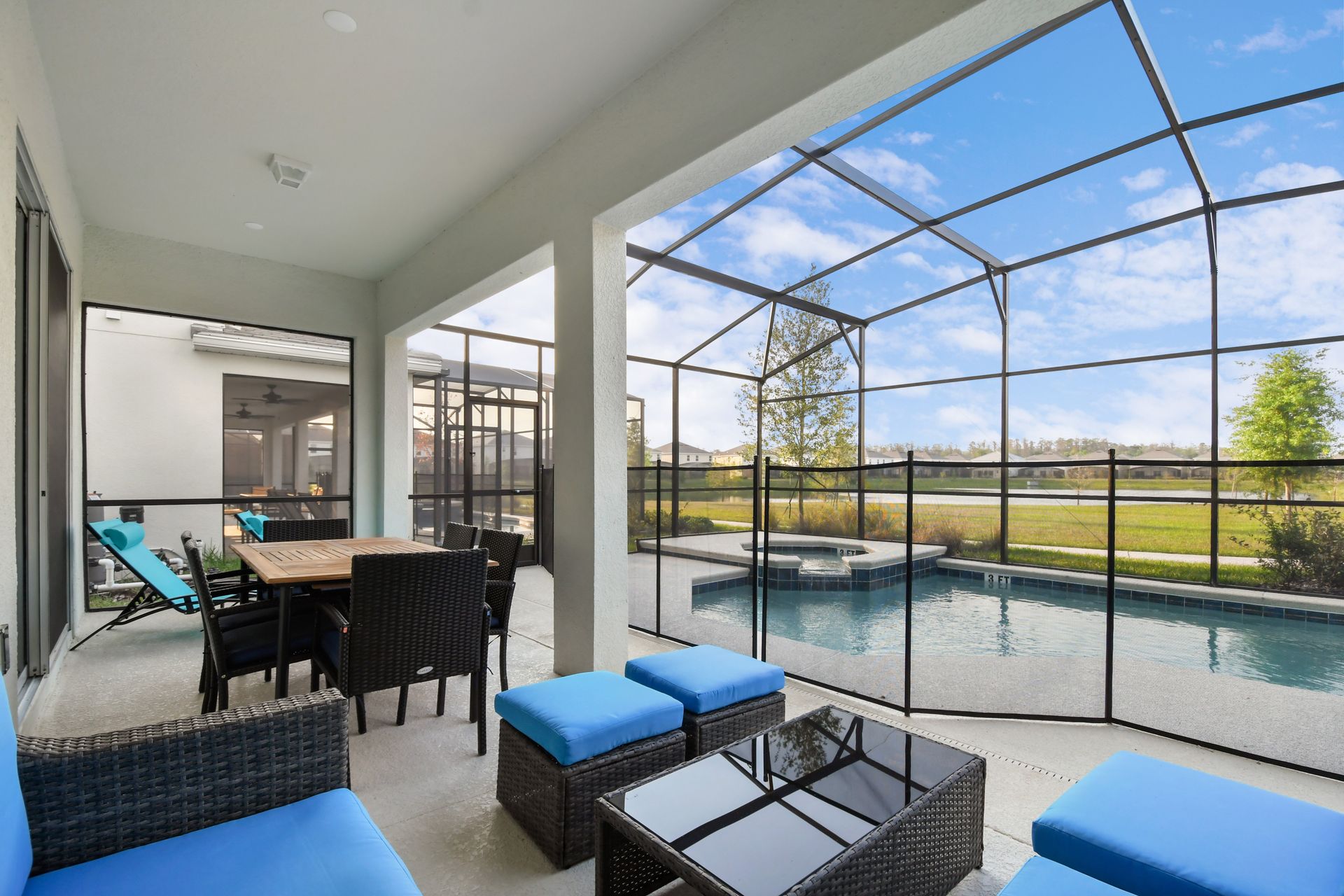 Relax on the covered patio with cozy seating and a dining area by the pool.