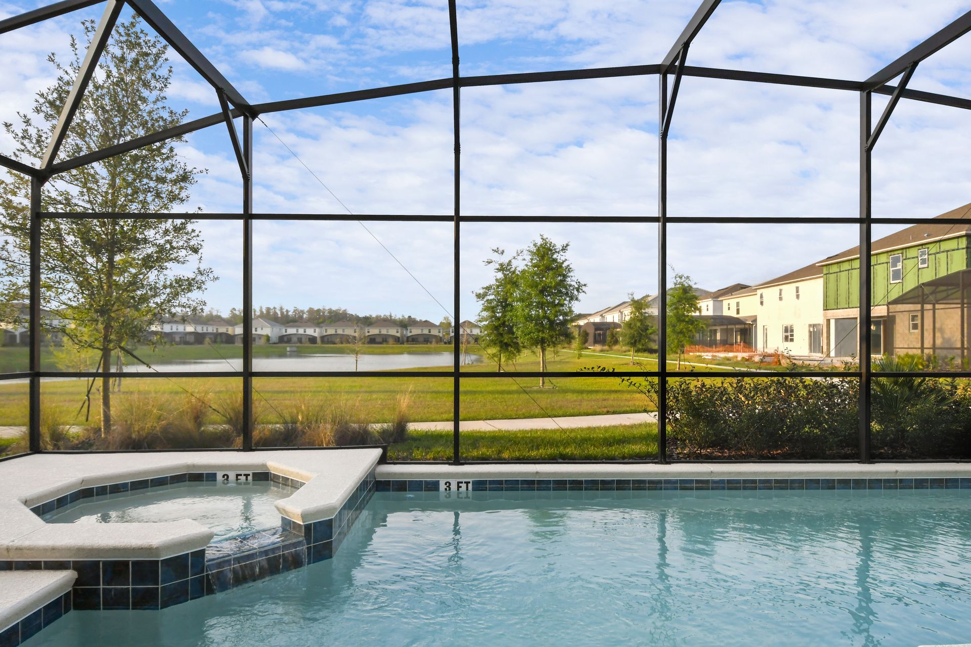 Spacious screened-in pool area with spa, lounge chairs, and outdoor seating.