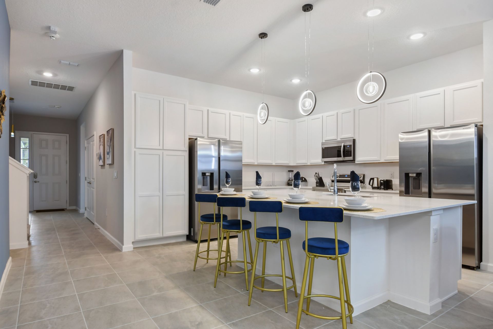 Sleek kitchen with white cabinetry, stainless appliances, and island seating—cook in style!