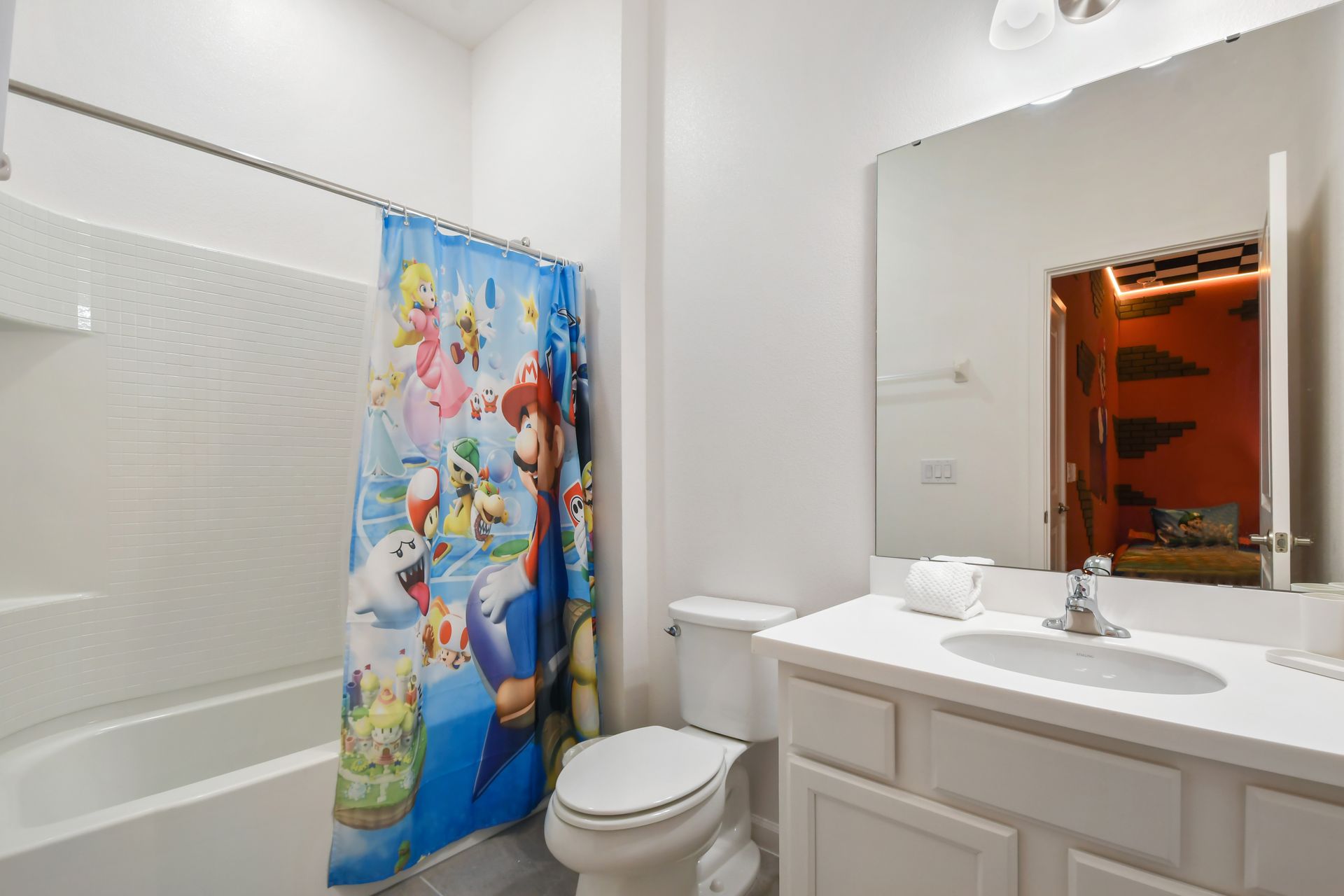 Fun Mario-themed bathroom with bright decor and a clean, white vanity.