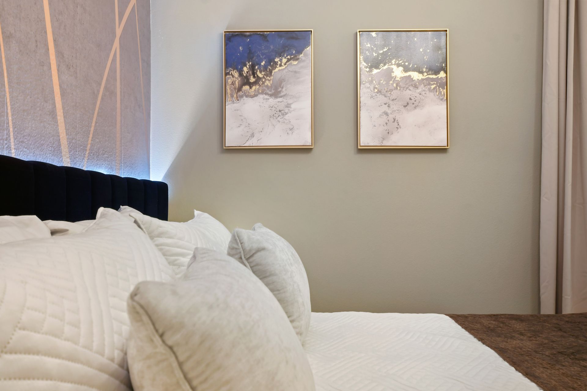 Elegant bedroom with abstract art, soft tones, and luxurious bedding—serene retreat