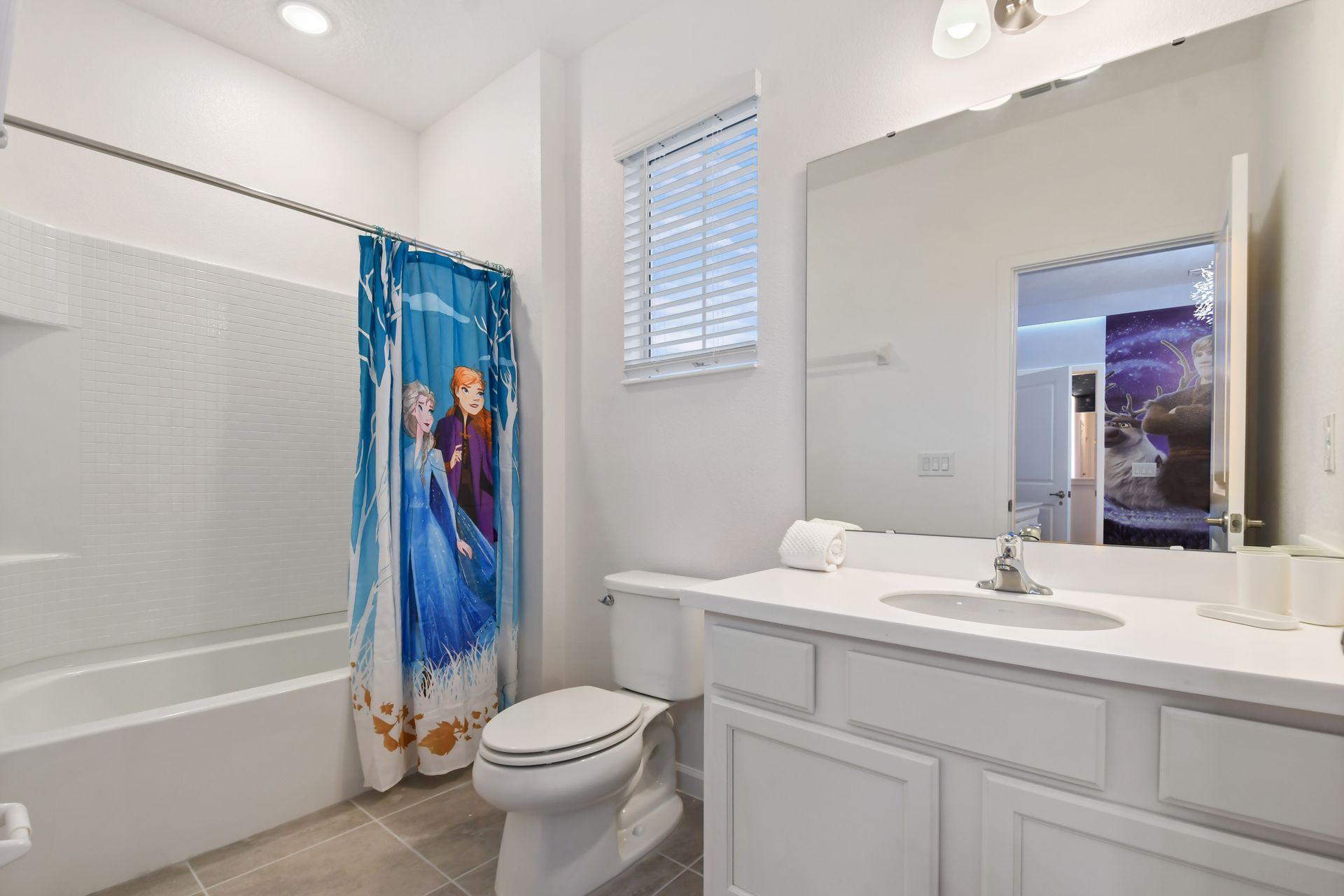 Charming bathroom with Frozen-themed decor, bright lighting, and modern fixtures.