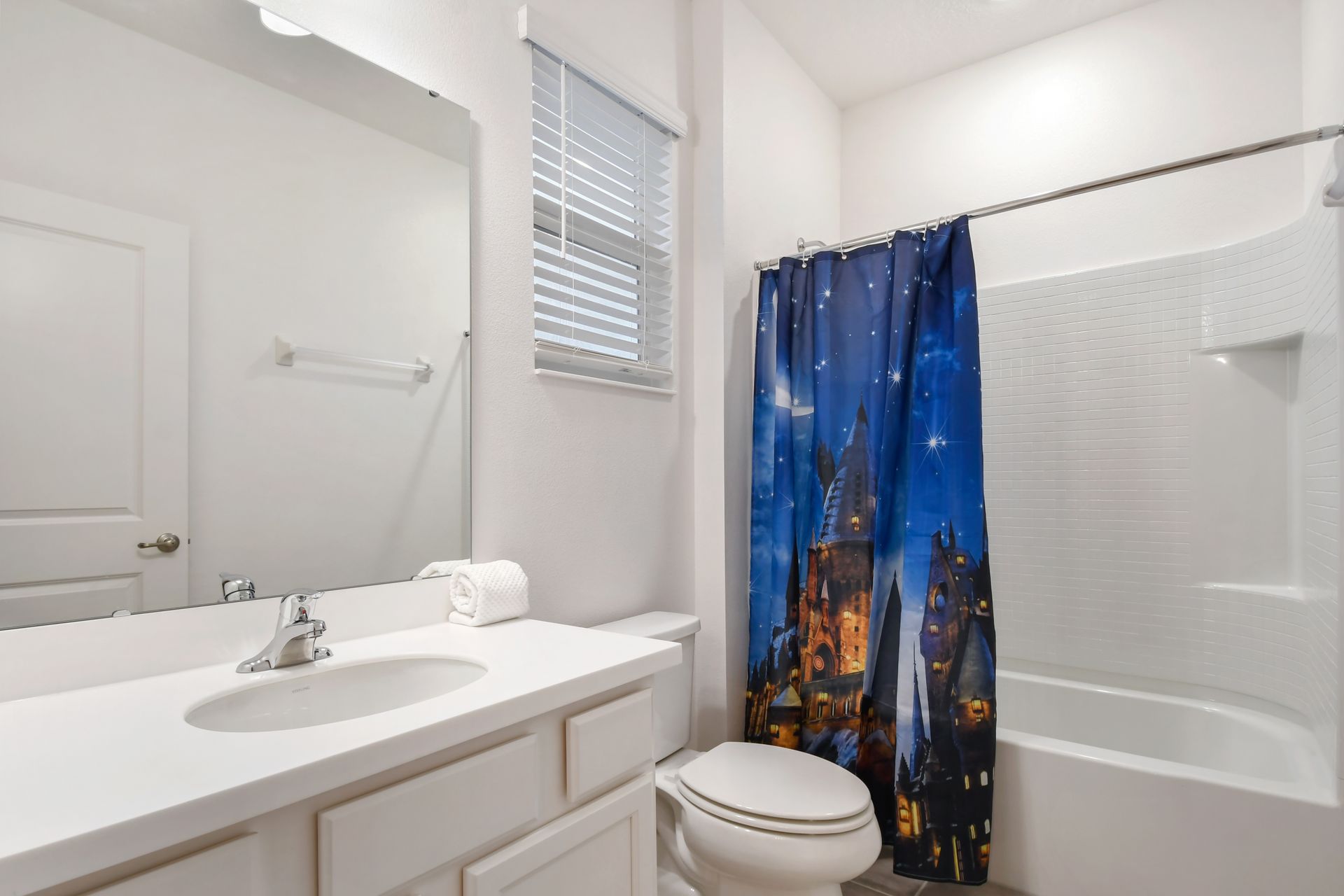 Magical-themed bathroom with a Hogwarts shower curtain and bright, clean design.