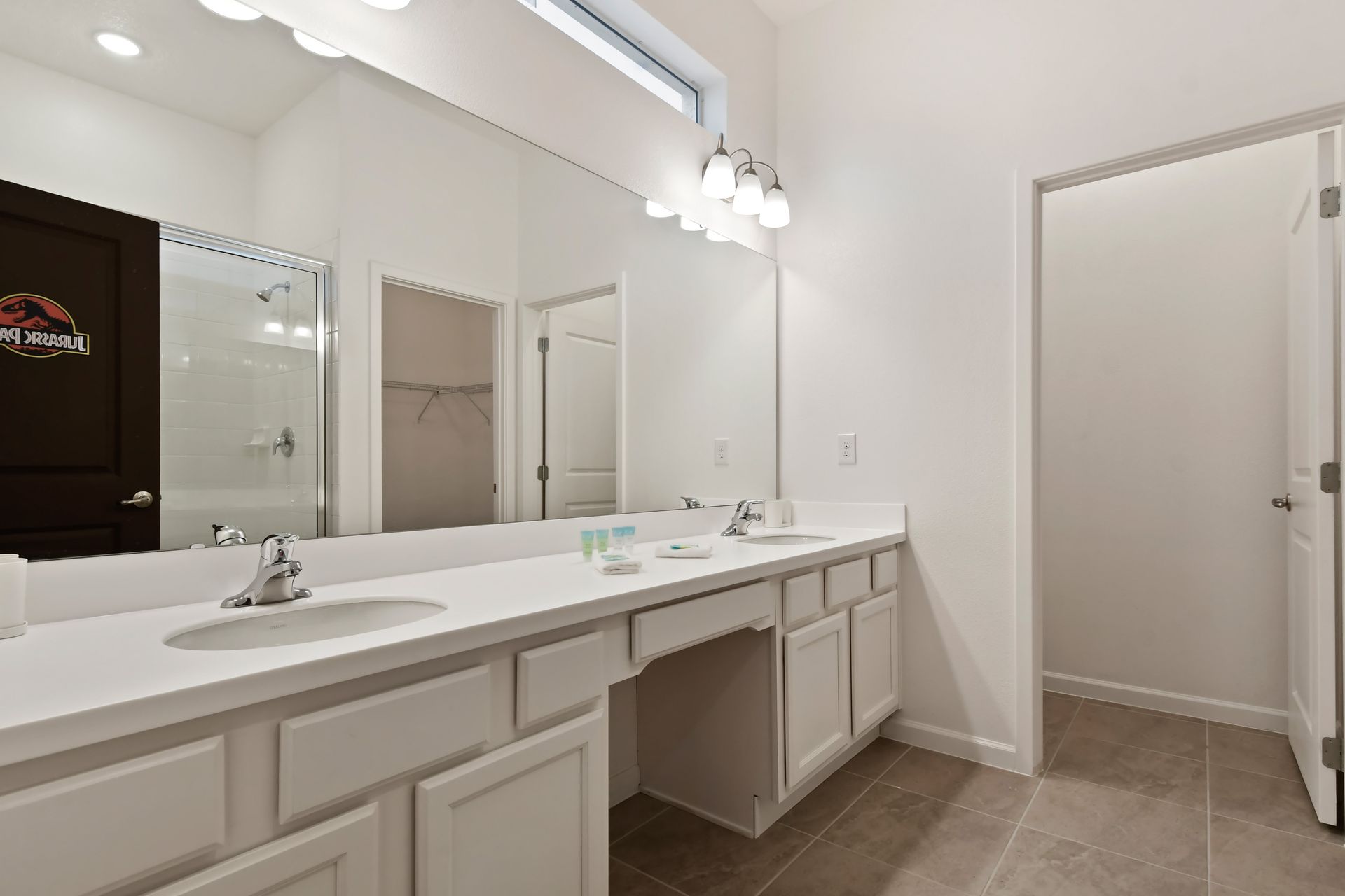 Spacious bathroom with dual sinks, a large mirror, and a walk-in shower.