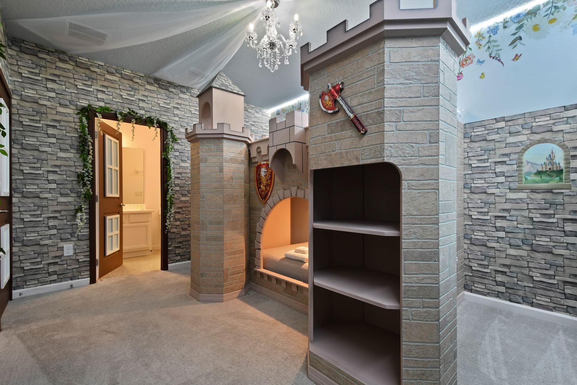 Castle-themed bedroom with stone walls, cozy nook, and chandelier—fairytale escape