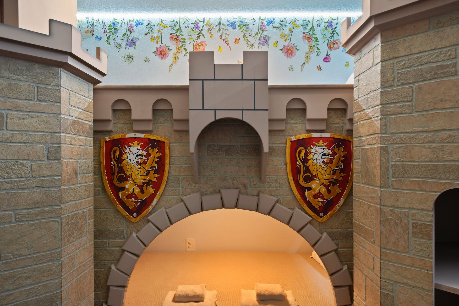 Medieval-themed nook with stone walls, lion shields, and floral accents—royal retreat