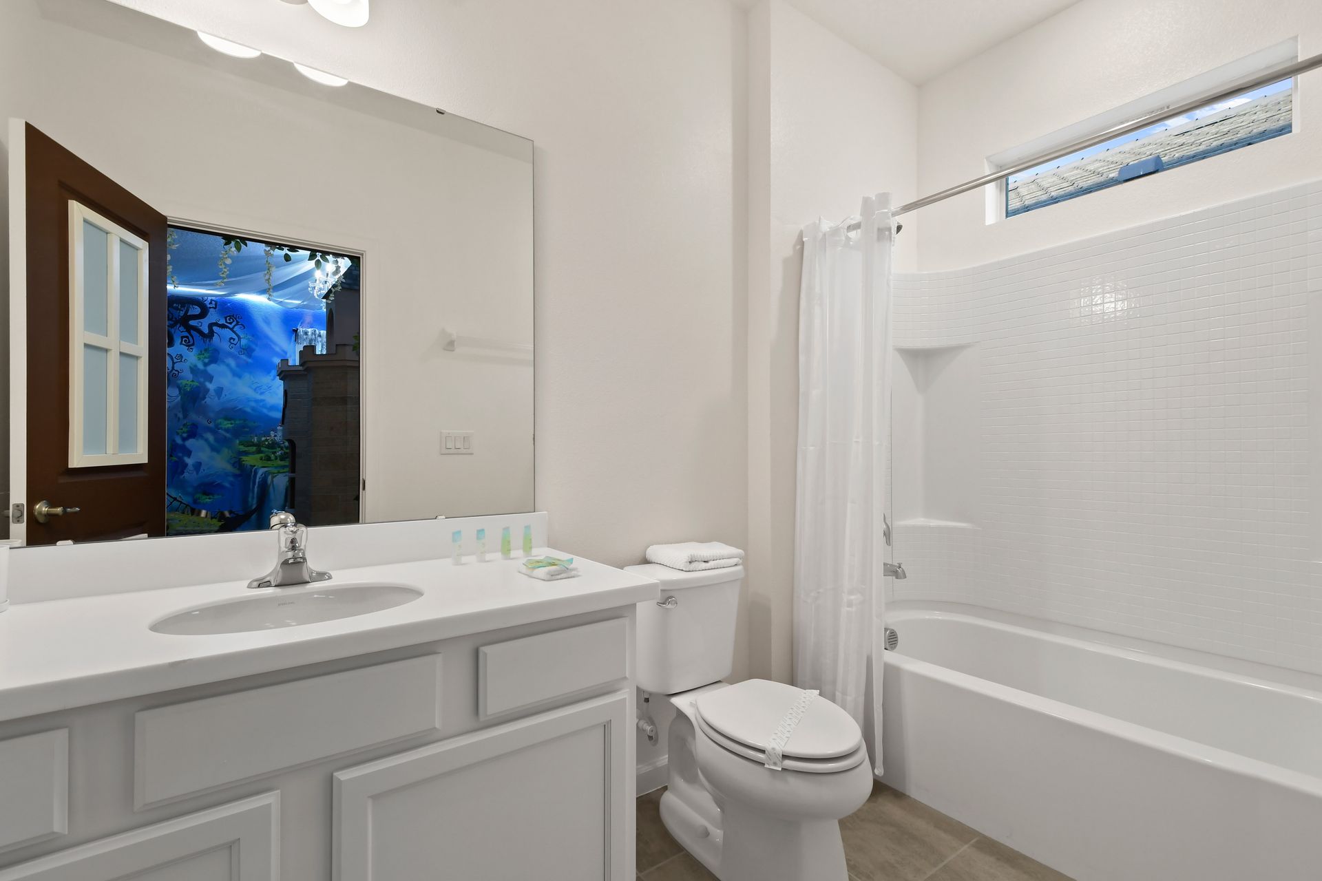 Bright bathroom with a clean design, shower-tub combo, and convenient amenities.