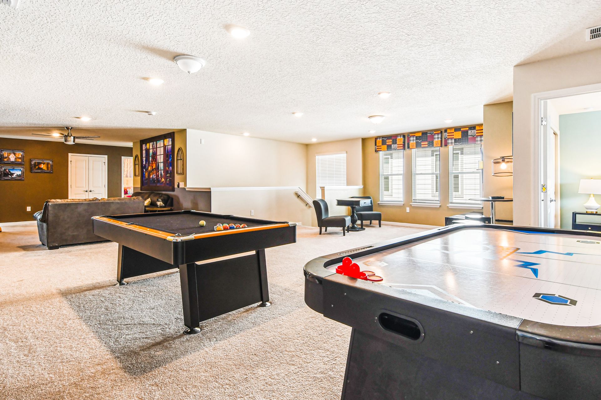 Spacious game room with pool table, air hockey, and lounge area