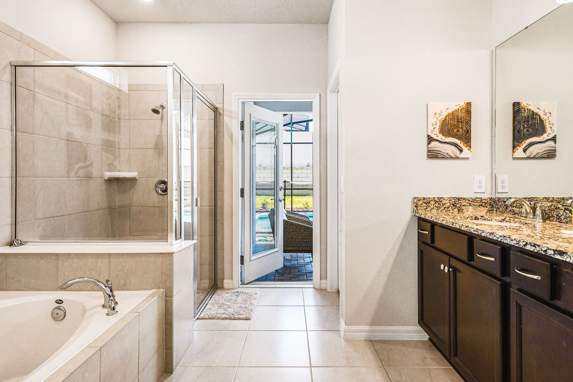 Luxurious ensuite with soaking tub, walk-in shower, and pool access.