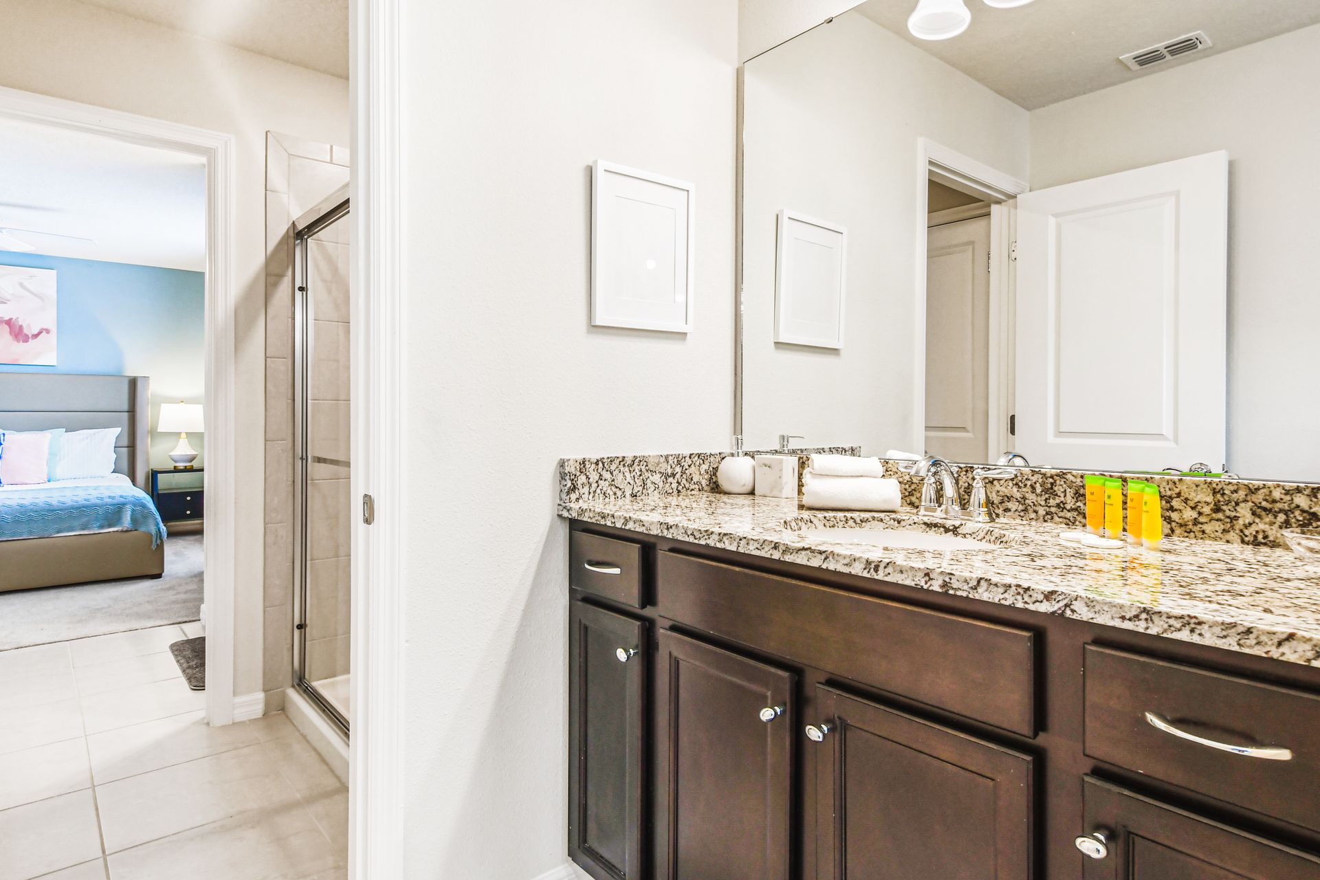 Modern bathroom with granite counters and a spacious walk-in shower.