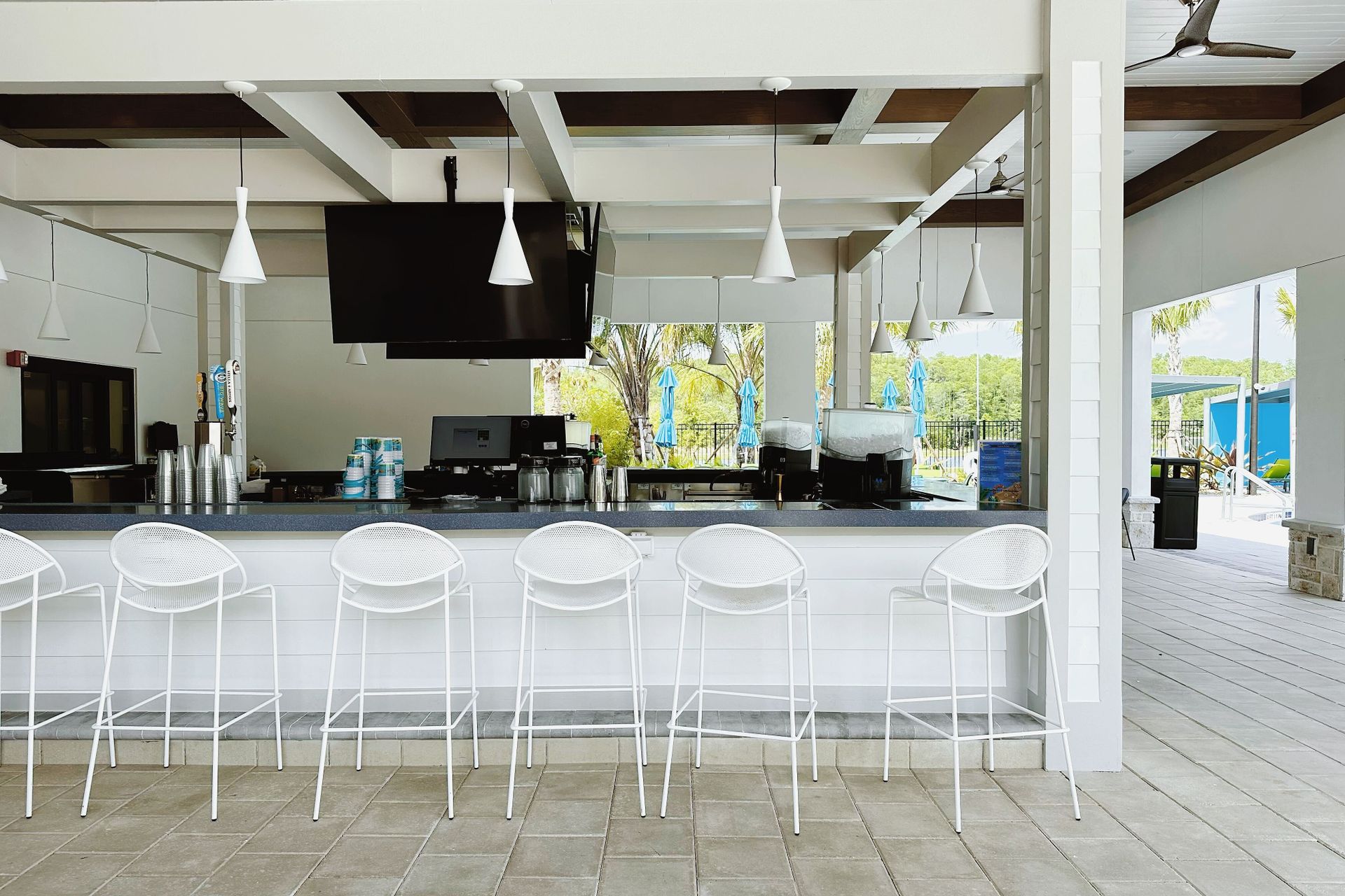 Resort Amenities - Sip on your favorite drinks at our poolside bar, offering you a refreshing way to unwind and relax during your stay.