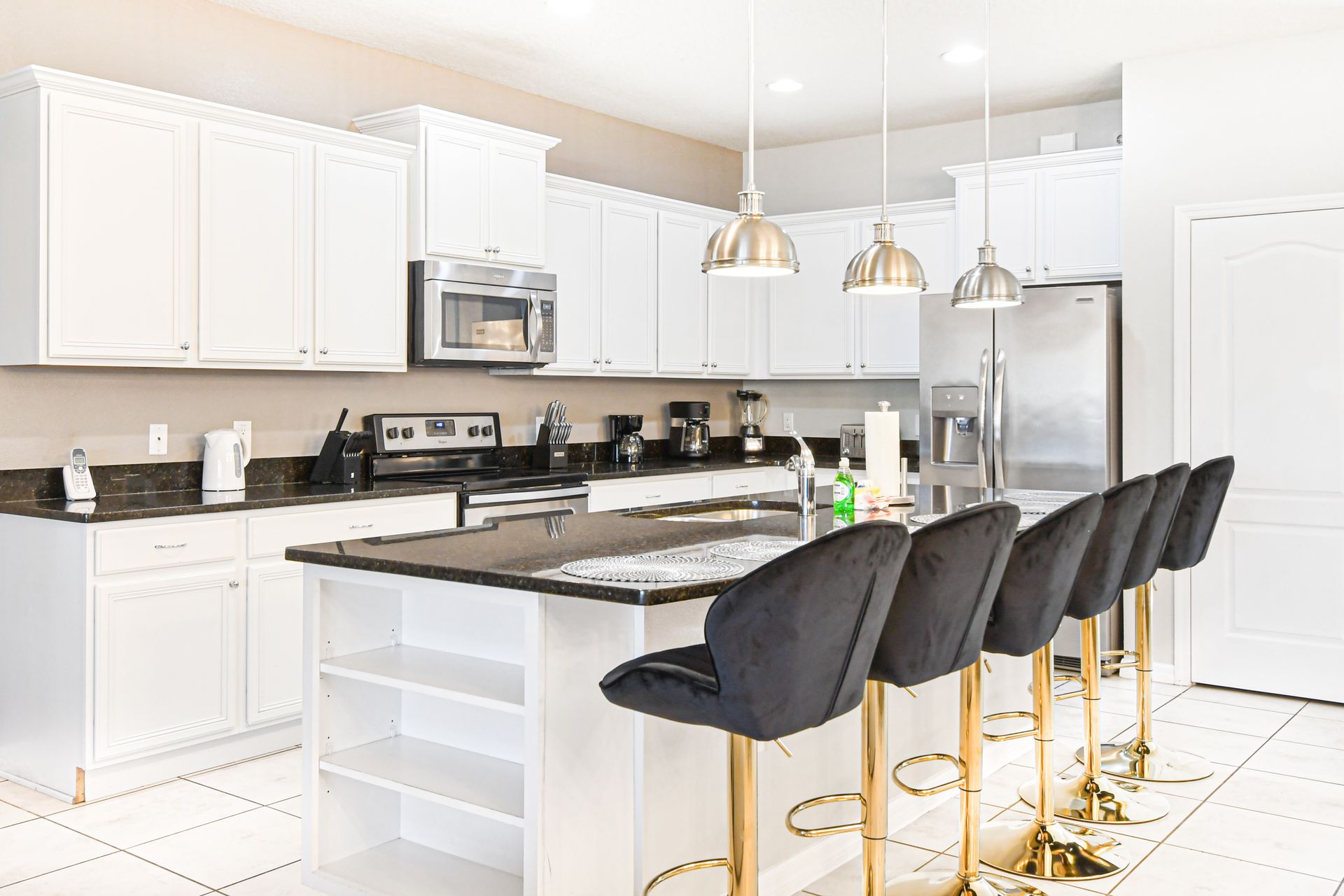 Stylish chef’s kitchen with granite island, modern appliances, and chic seating.