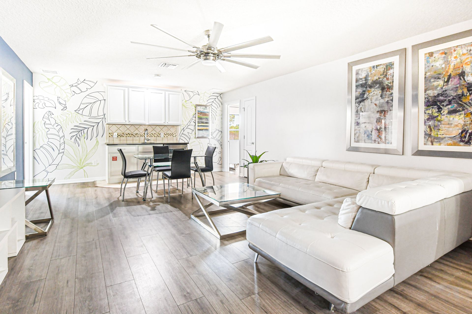 Bright modern lounge with chic décor, stylish seating, and open kitchenette space.