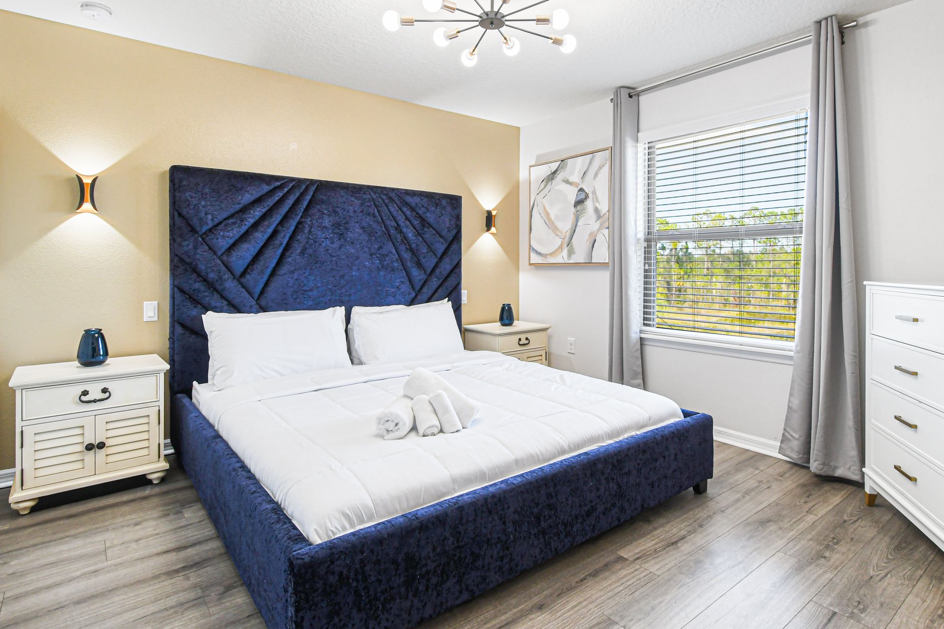 Relaxing bedroom with modern décor, cozy bed, and plenty of natural light.