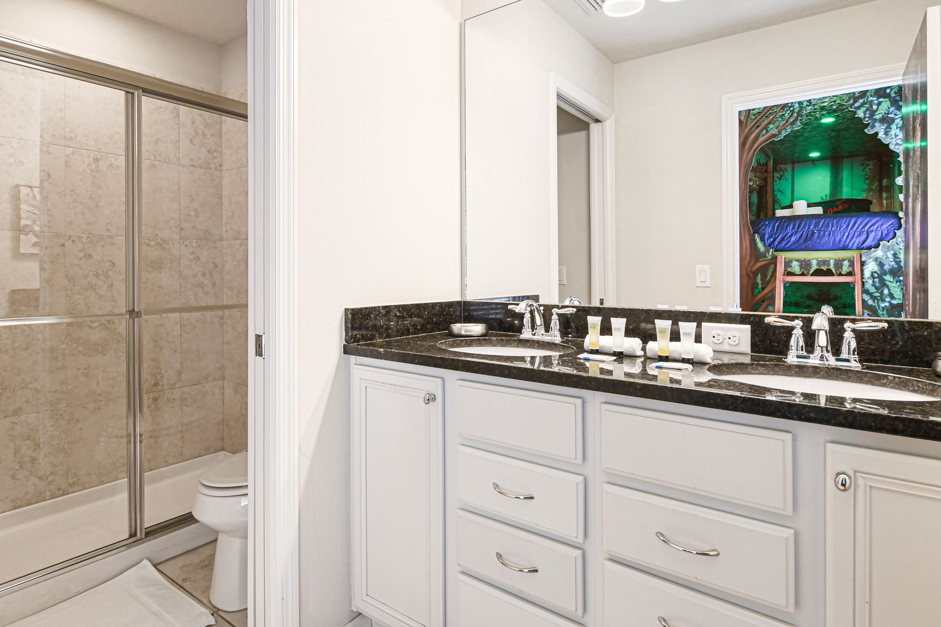 Modern bathroom with granite counters, dual sinks, and sleek glass walk-in shower.