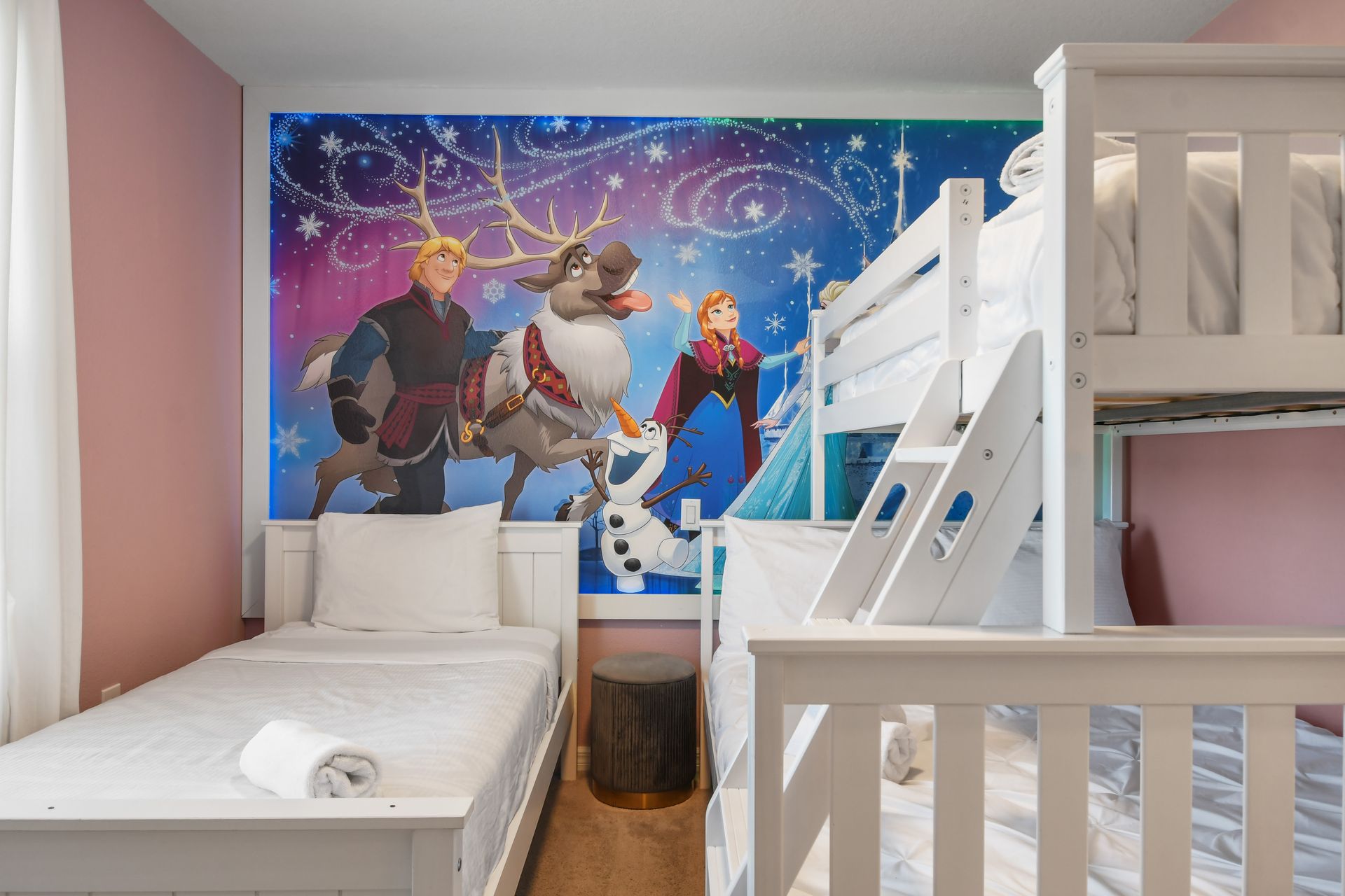 Frozen-themed room with cozy beds, vibrant decor, and a magical winter wonderland feel.