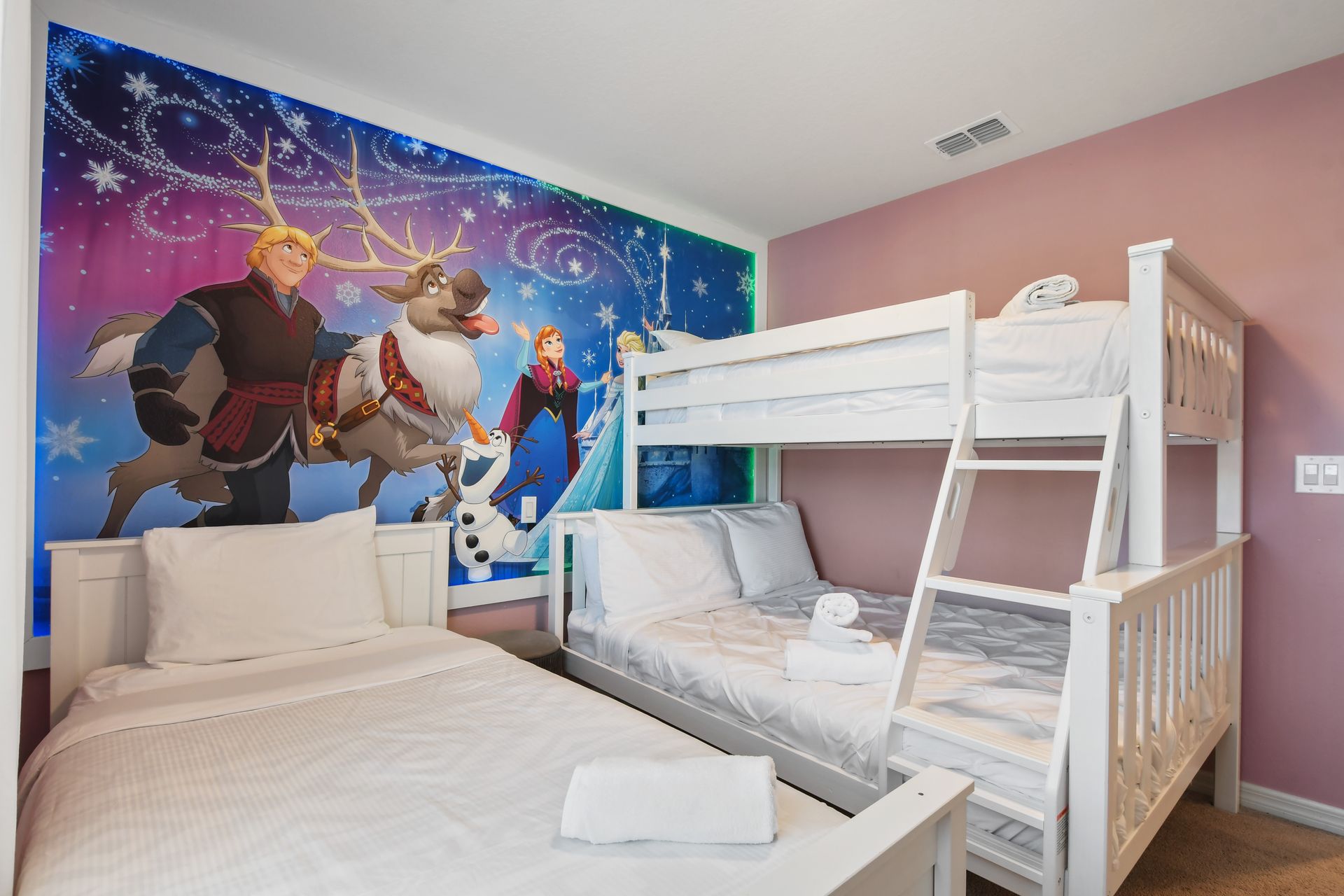 Frozen-themed room with cozy beds, vibrant decor, and a magical winter wonderland feel.