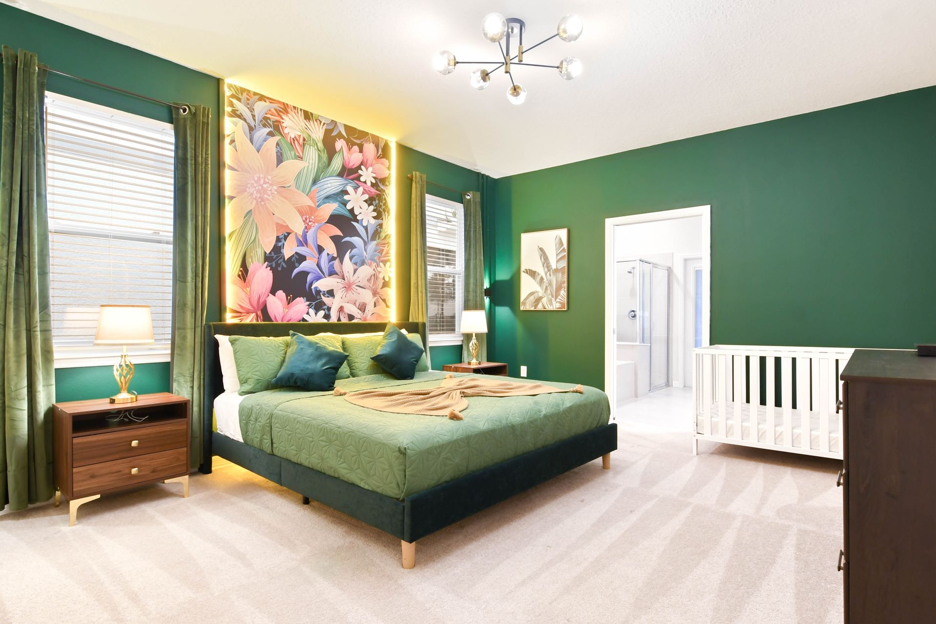 Tropical-inspired master suite with bold floral art, king bed, and private crib.