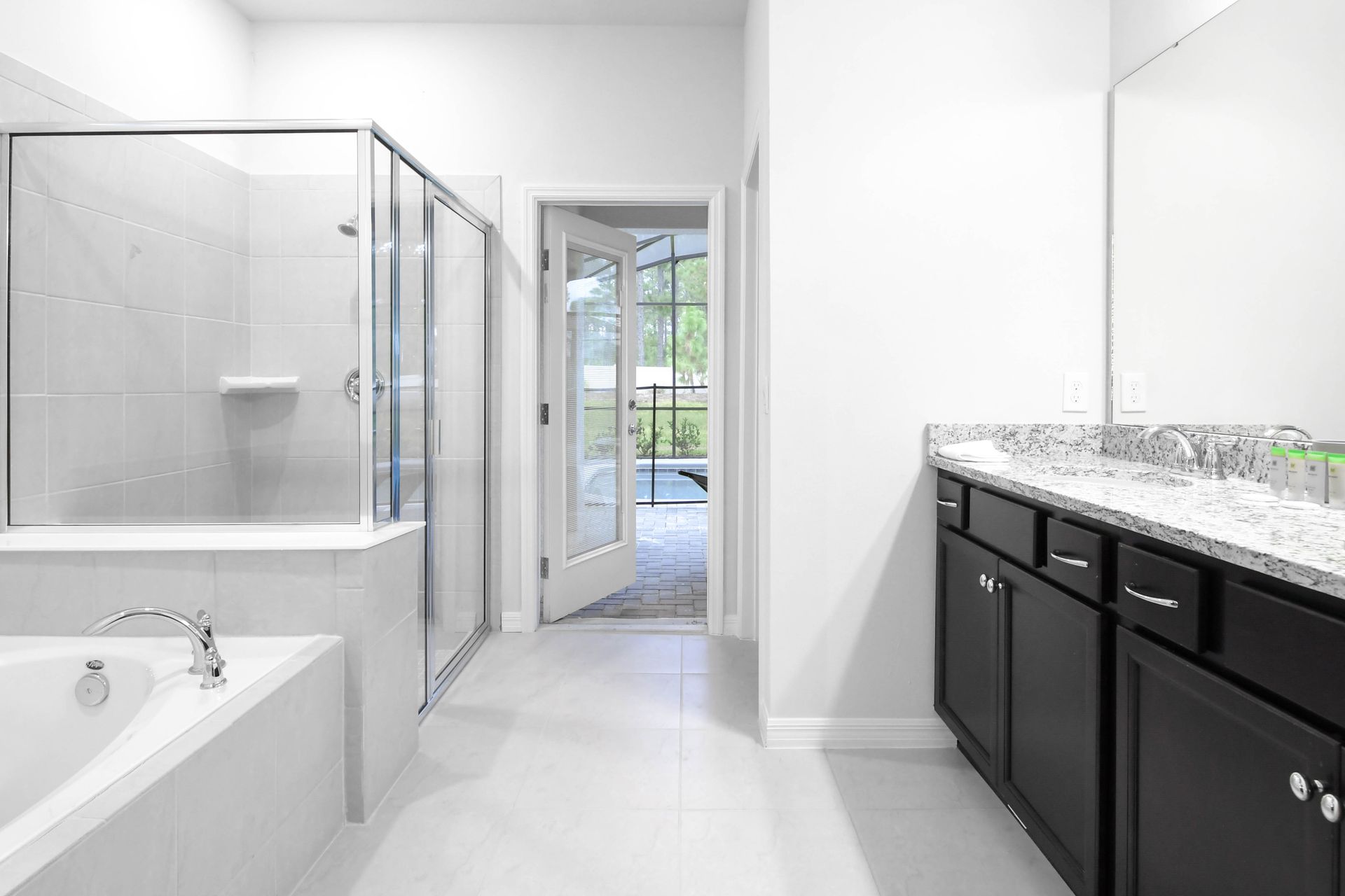 Spacious ensuite bath with walk-in shower, soaking tub, double vanity, and pool access.