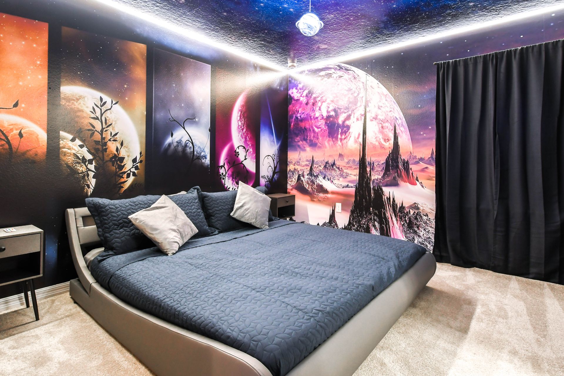 Cosmic-themed bedroom with galaxy murals, ambient lighting, and a king-size bed.