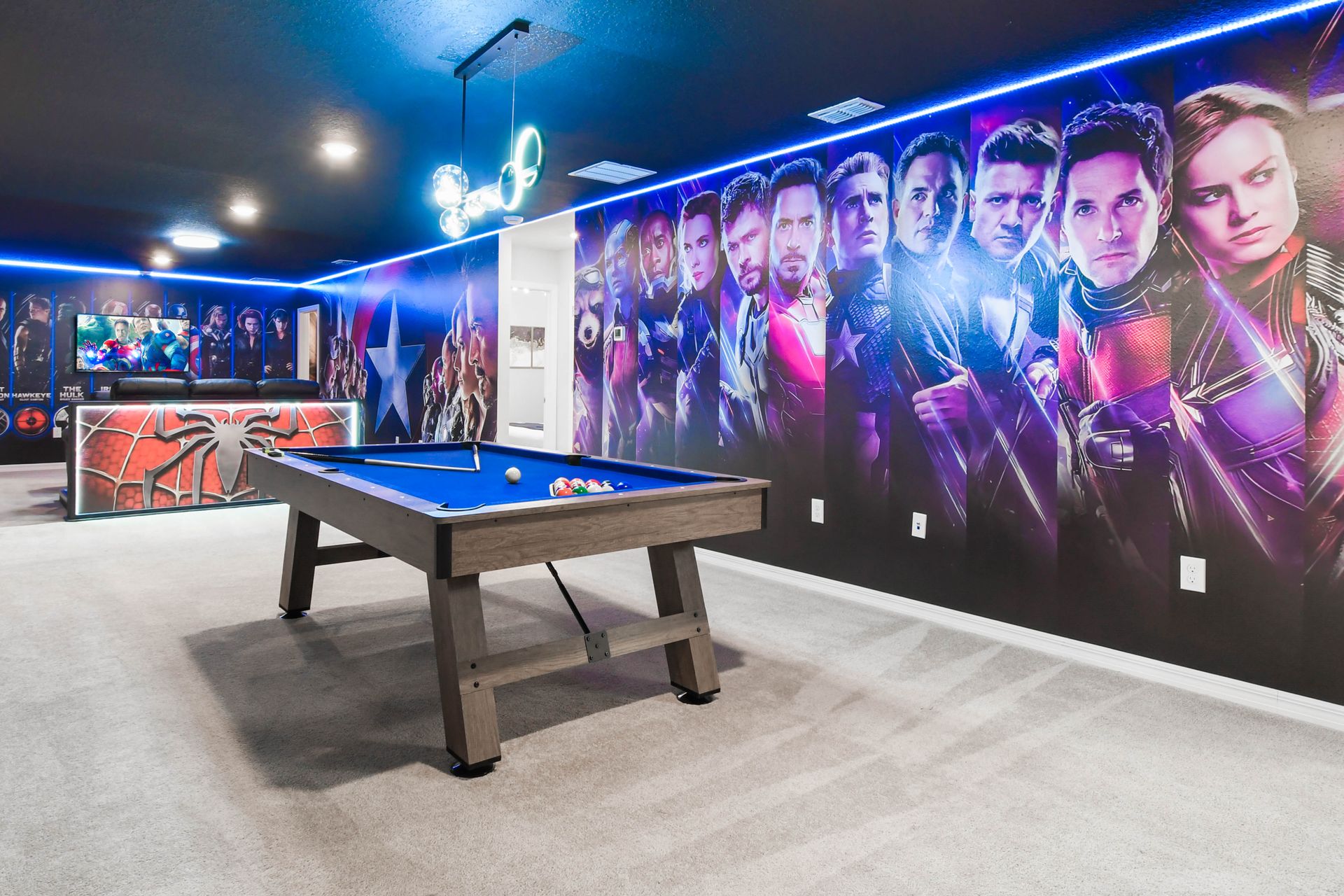Superhero-themed billiards room with bold wall art, vibrant lighting, and fun vibes.