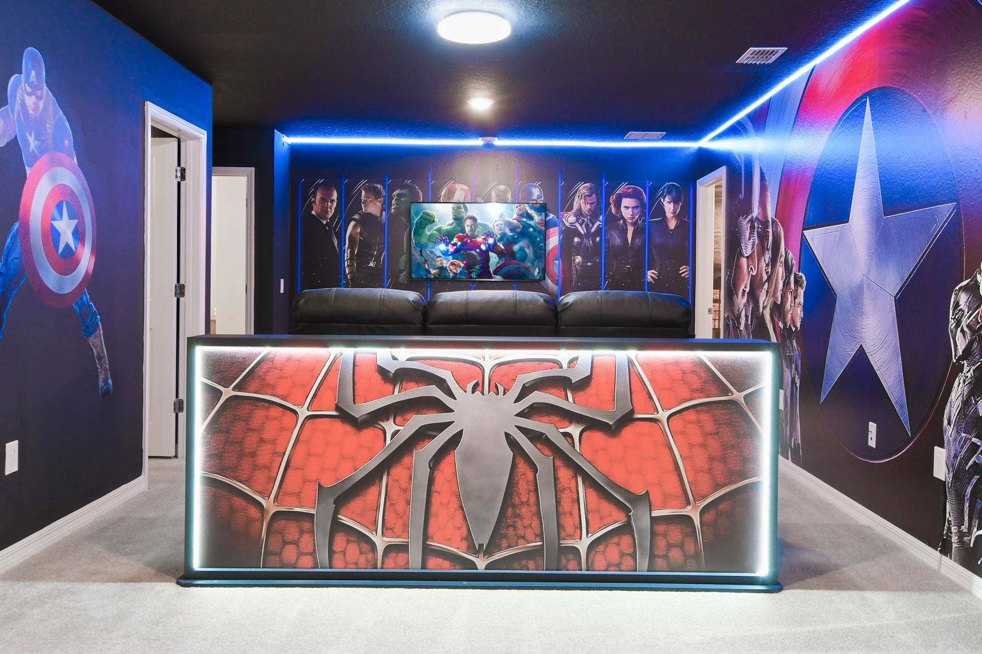 Superhero-themed theater room with LED lighting, bold murals, and cozy seating.