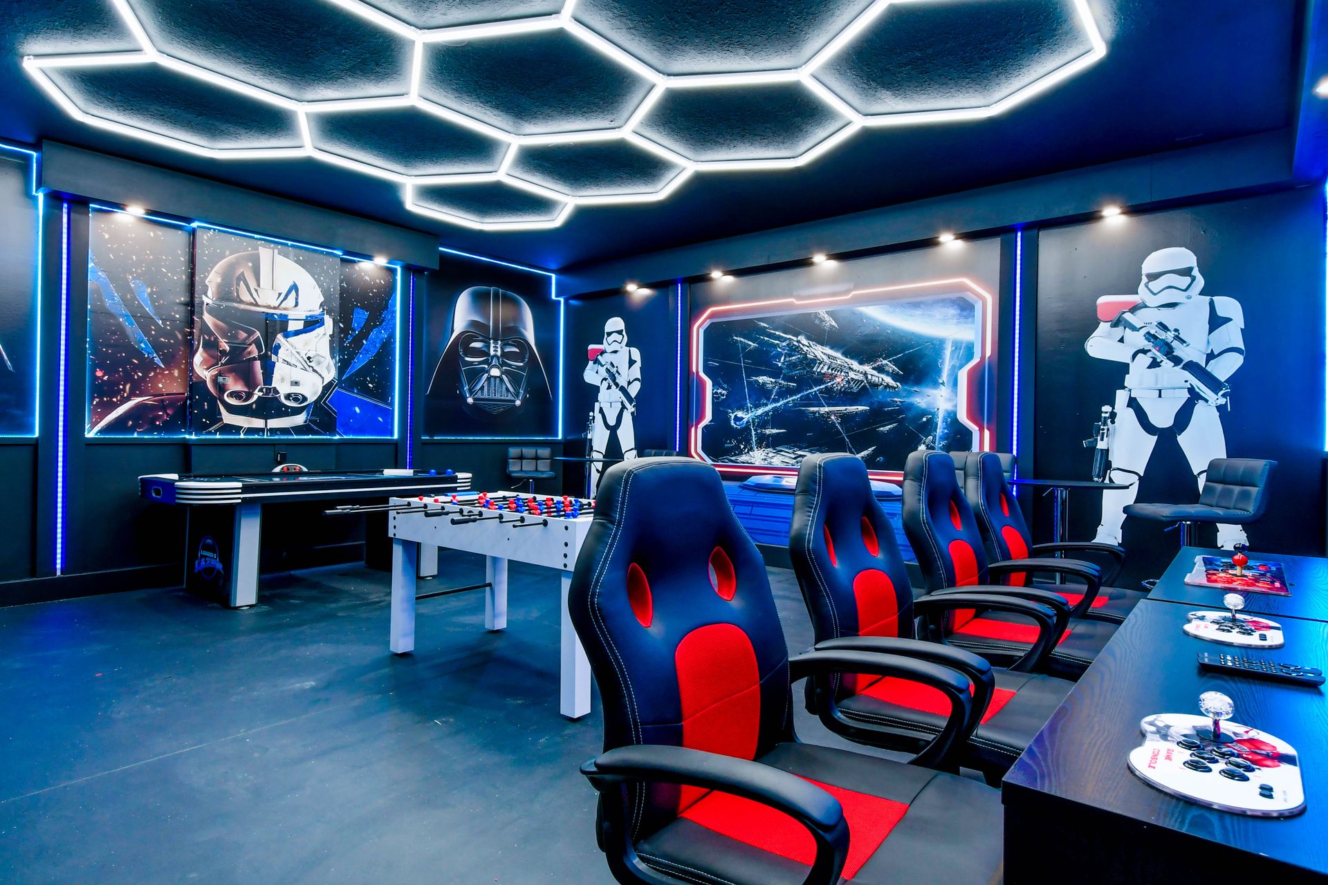 Galactic-themed arcade room with air hockey, foosball, and retro gaming stations.