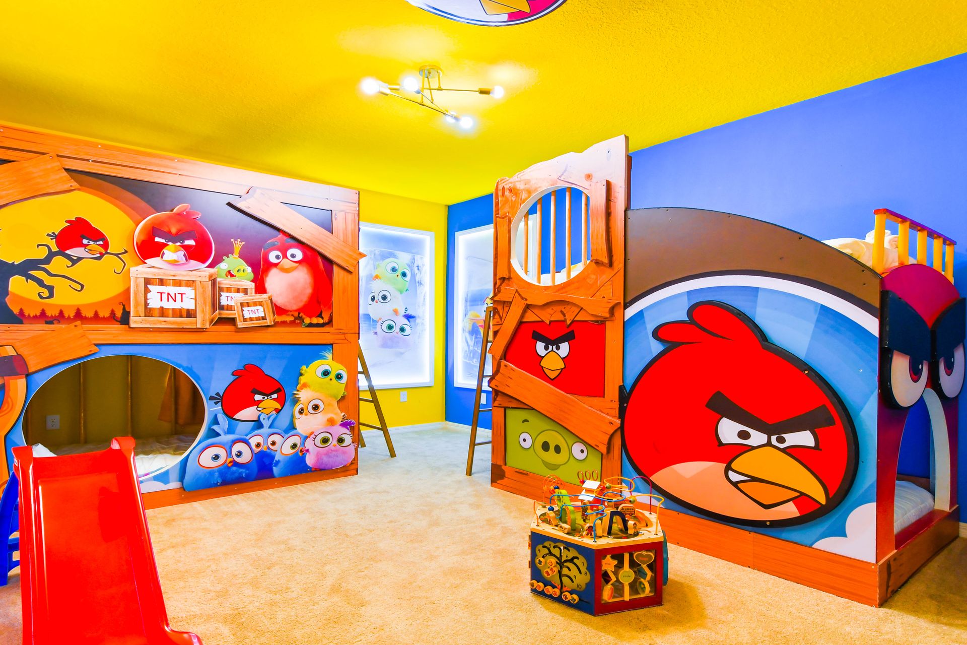 Vibrant Angry Birds-themed room with custom bunk beds, slides, and playful art.