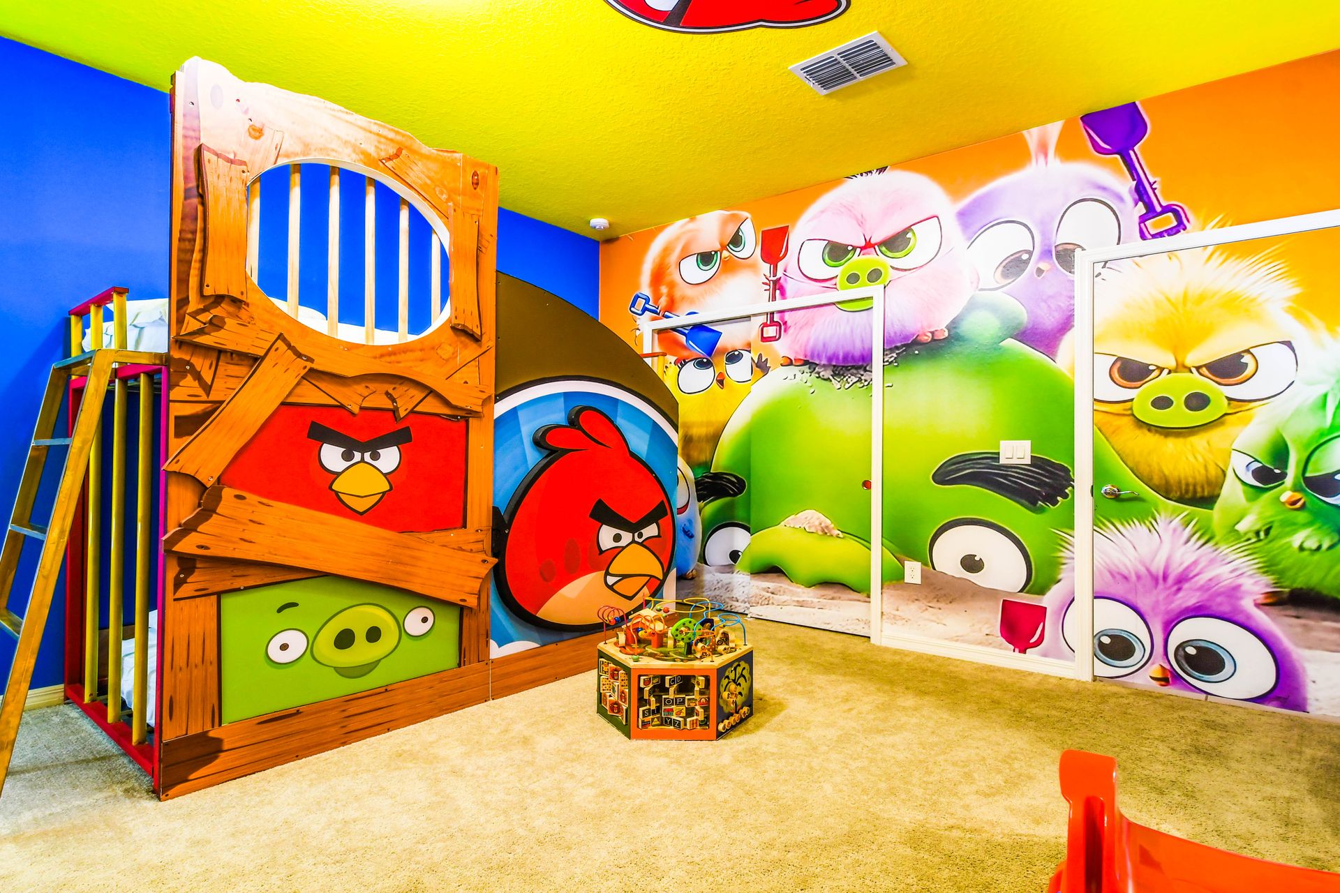 Vibrant Angry Birds-themed room with custom bunk beds, slides, and playful art.