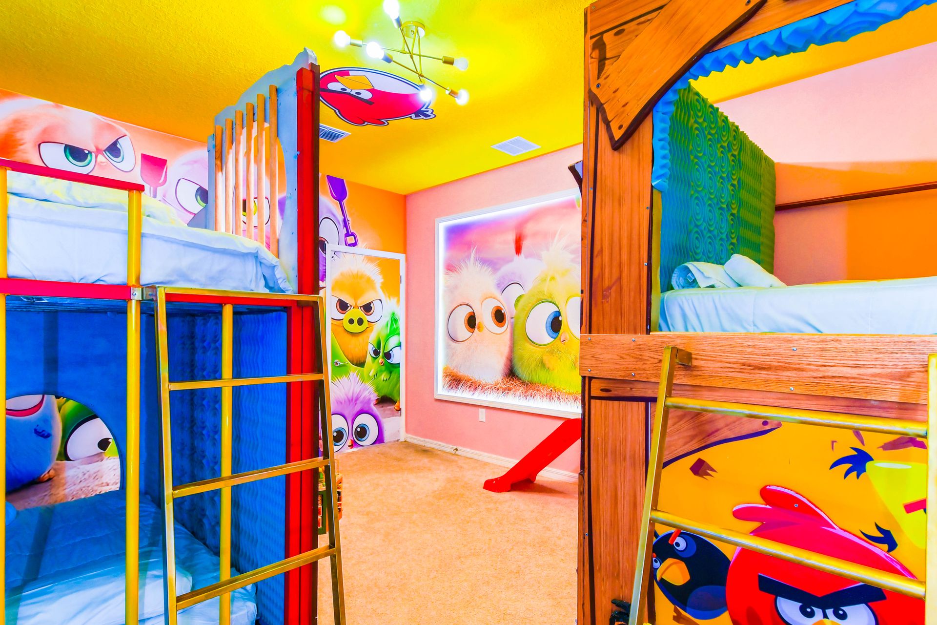 Vibrant Angry Birds-themed room with custom bunk beds, slides, and playful art.