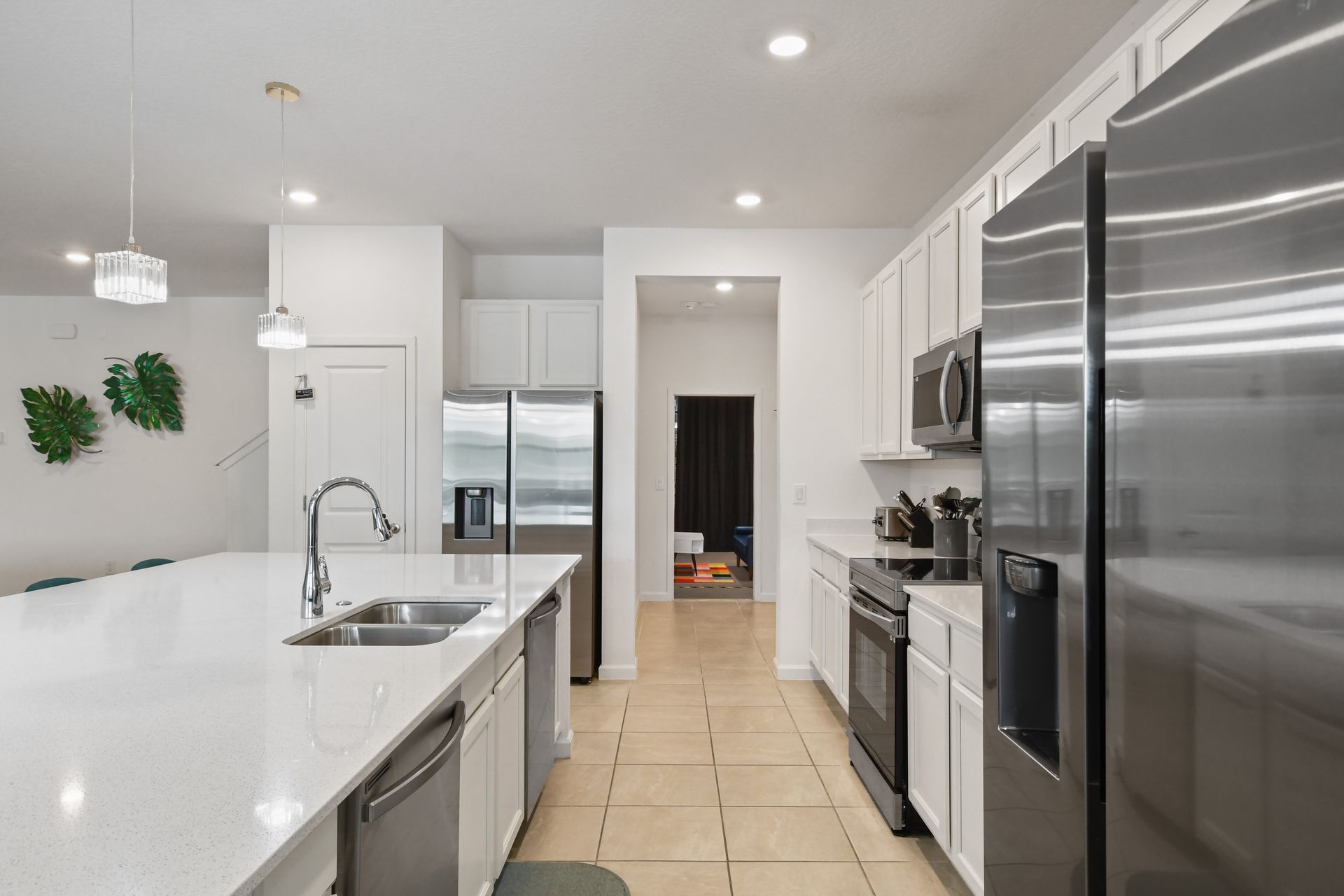 Sleek modern kitchen with stainless steel appliances, a spacious island, and chic lighting!