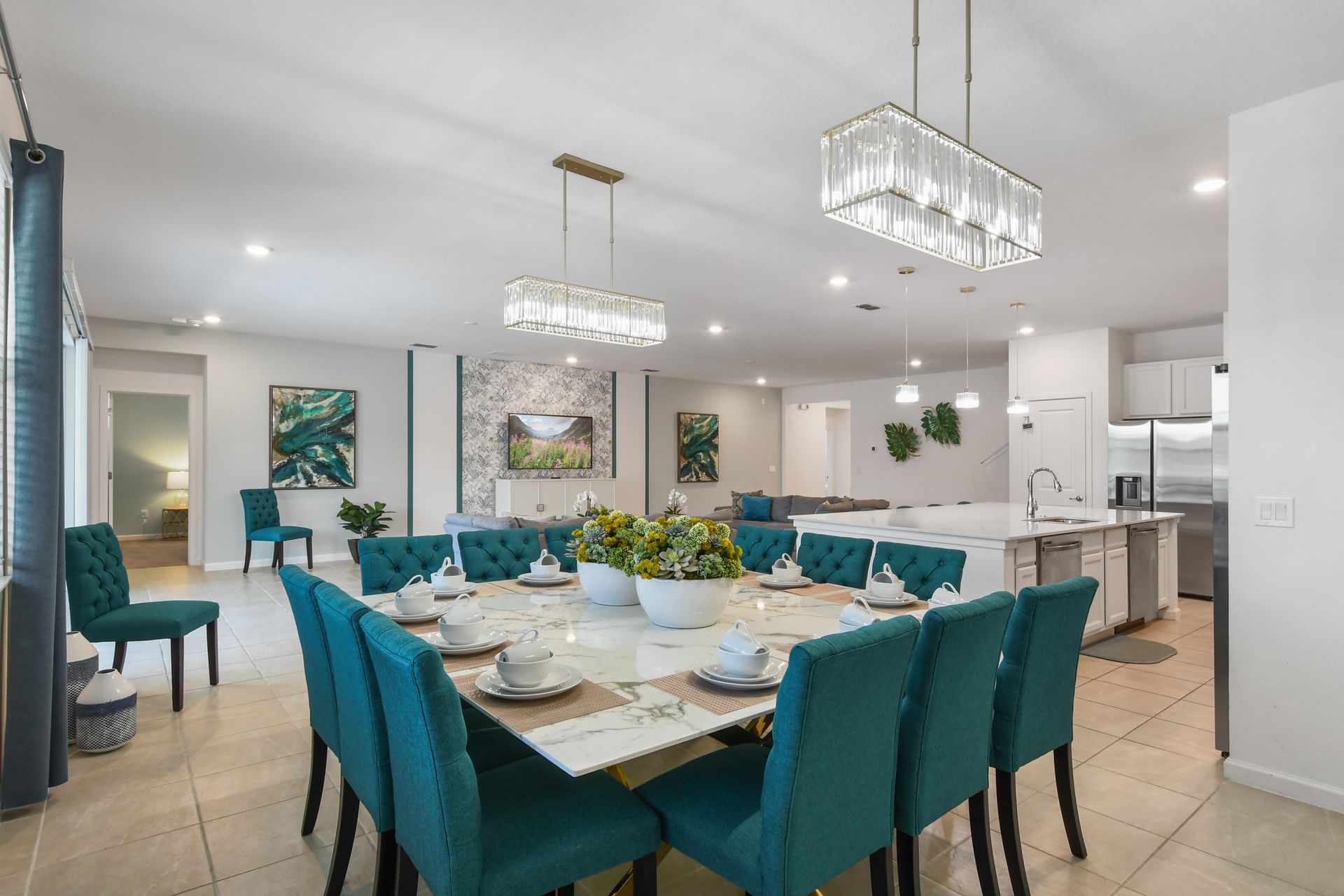 Elegant open-concept dining area with a marble table, plush seating, and chic lighting!