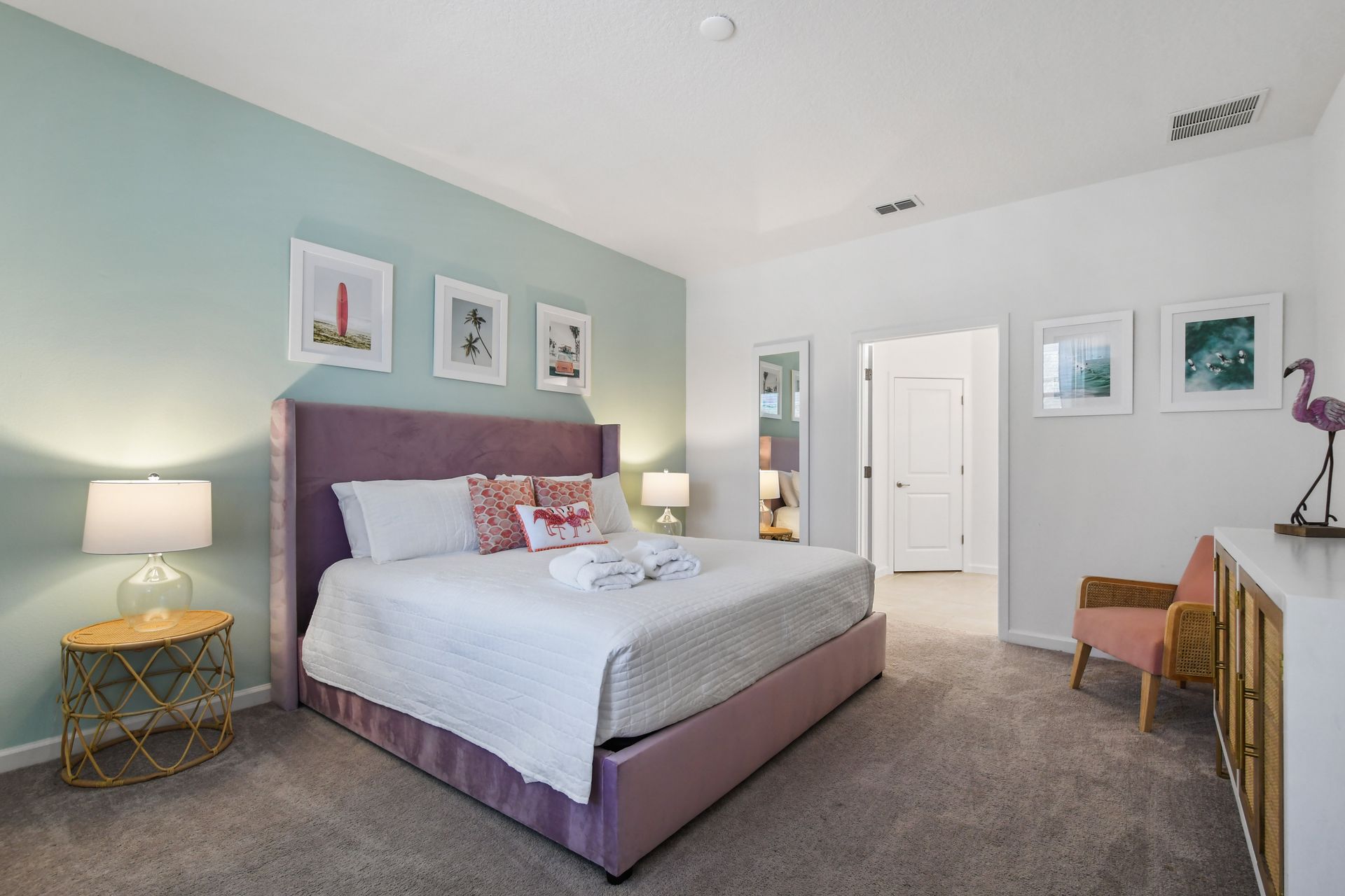 Chic tropical-themed bedroom with a plush bed, soft pastels, and relaxing vibes!