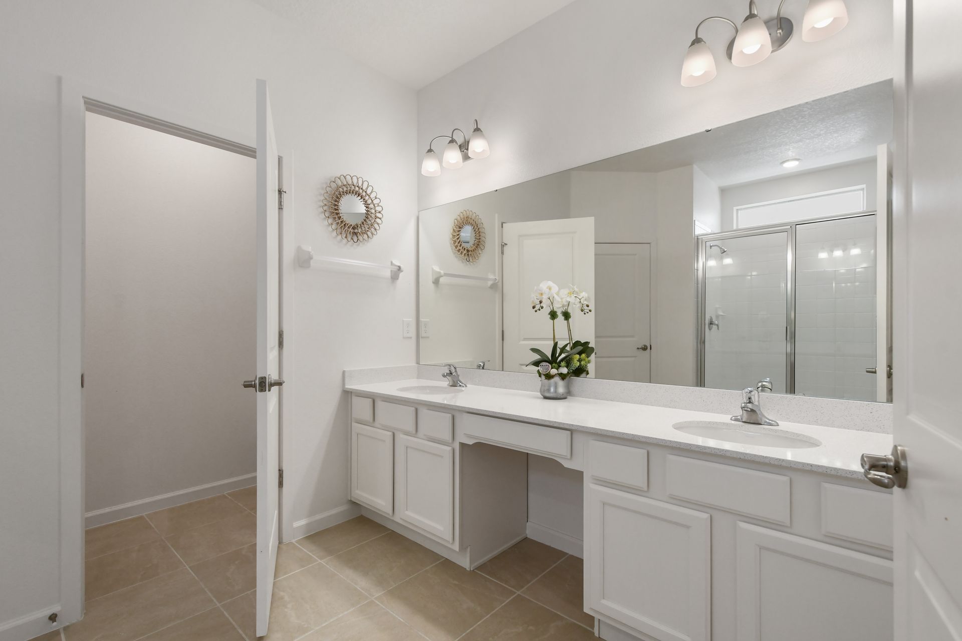 Elegant bathroom with dual sinks, walk-in shower, and modern lighting. Relax here!