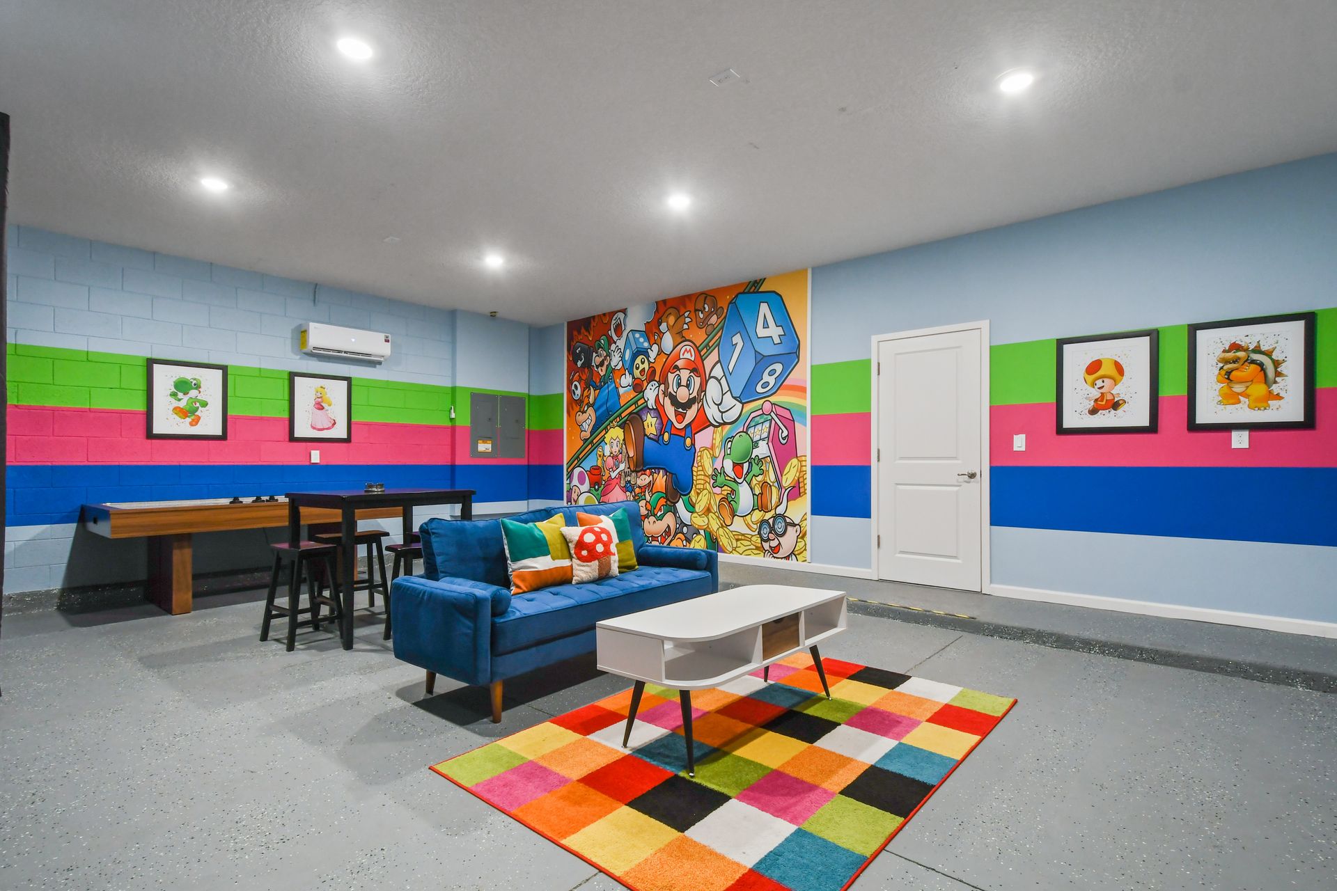 A fun and vibrant game room with arcade decor, seating areas, and game tables - providing entertainment for guest of all ages.