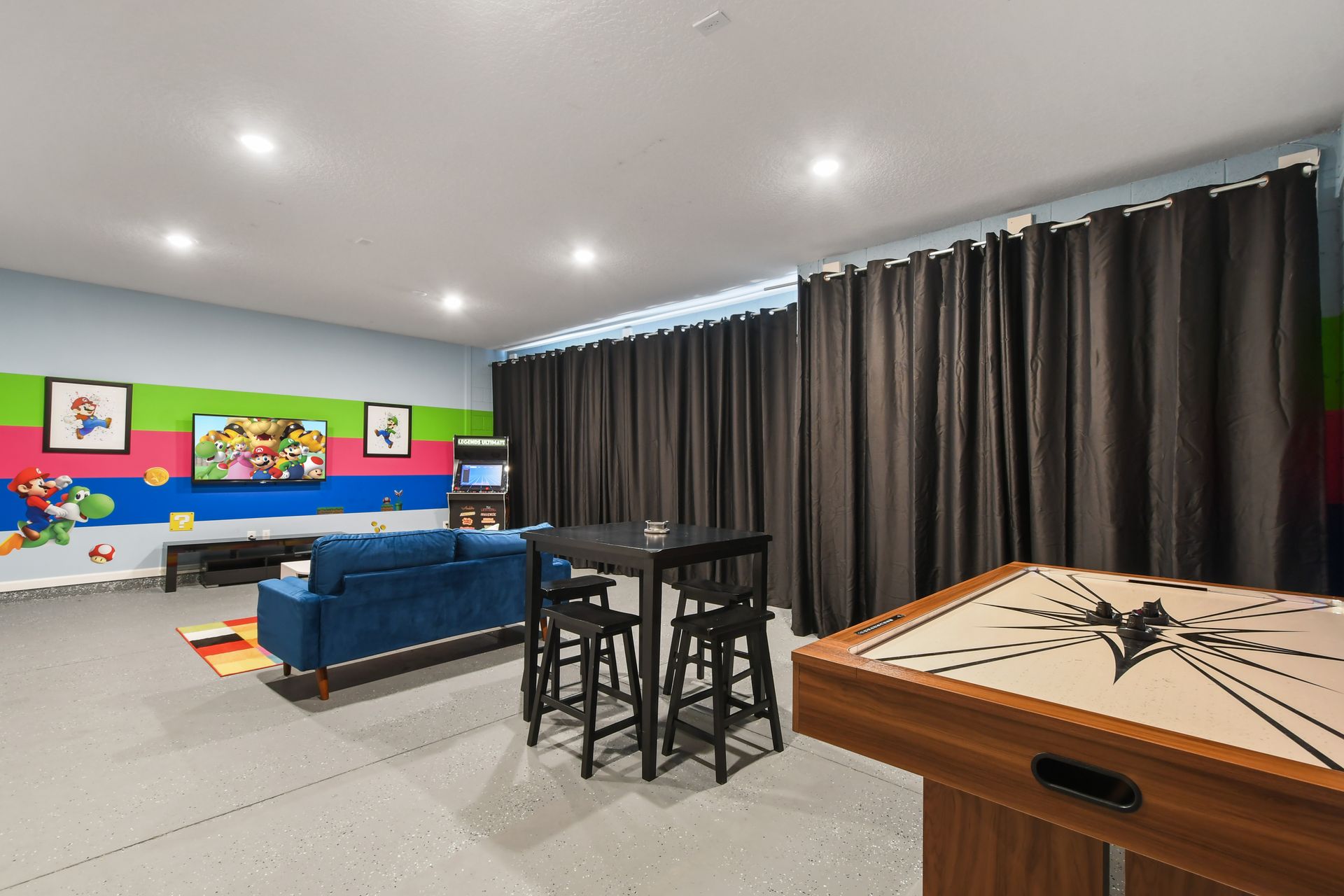 Exciting game room with arcade games, air hockey, and a fun Mario-themed design!