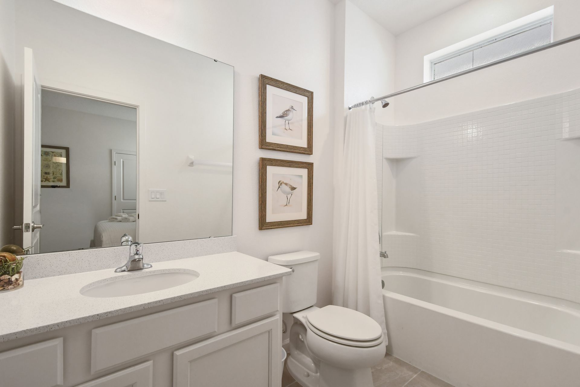 Bright coastal-themed bathroom with a tub, perfect for a relaxing getaway! 