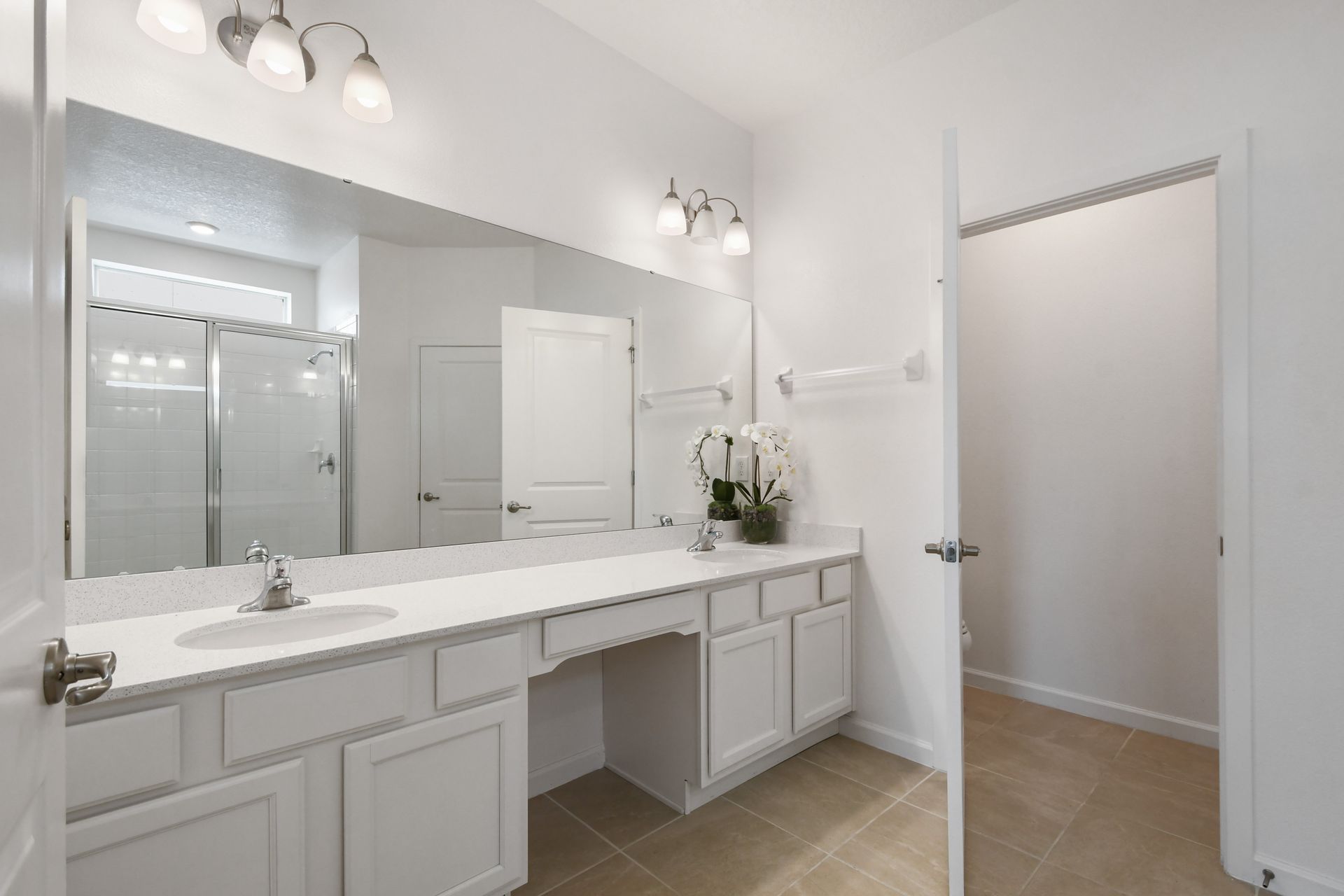 Elegant bathroom with dual sinks, walk-in shower, and modern lighting. Relax here!