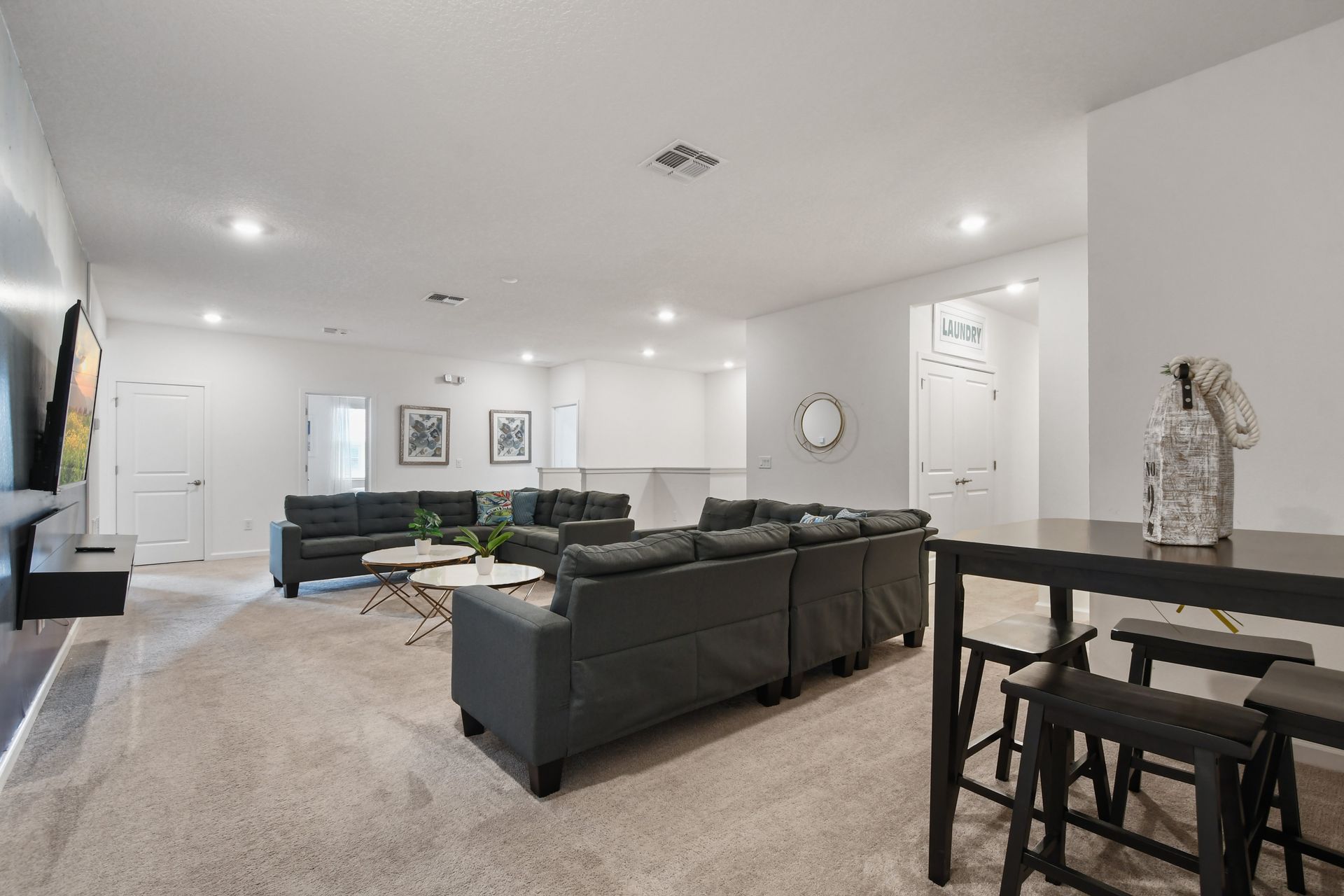 Spacious upstairs lounge with plush seating, cozy vibes, and a stylish entertainment area!