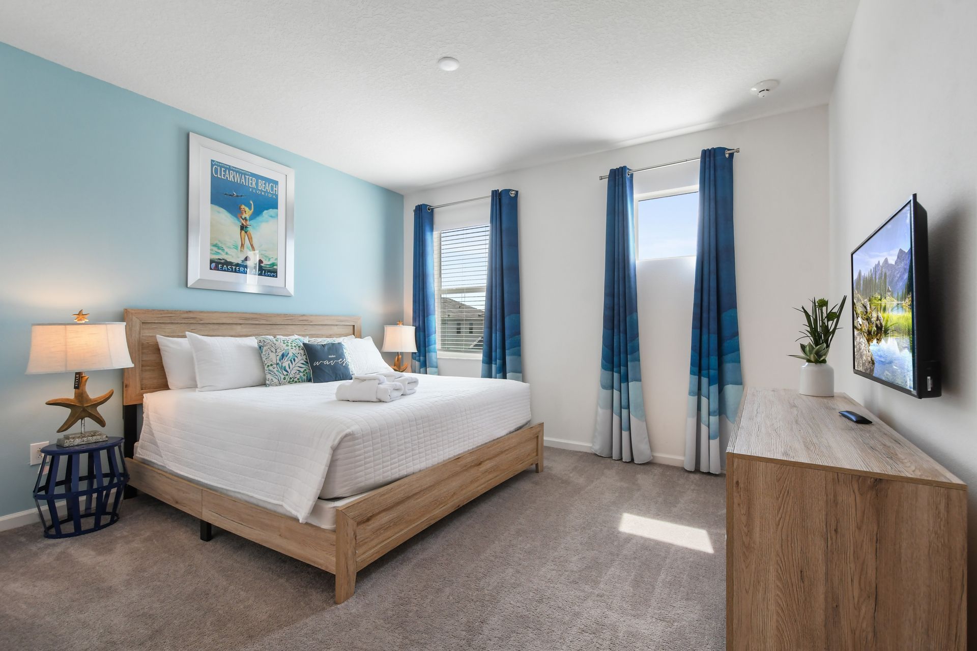 Coastal-inspired bedroom with serene blue tones, a cozy bed, and beachy décor!
