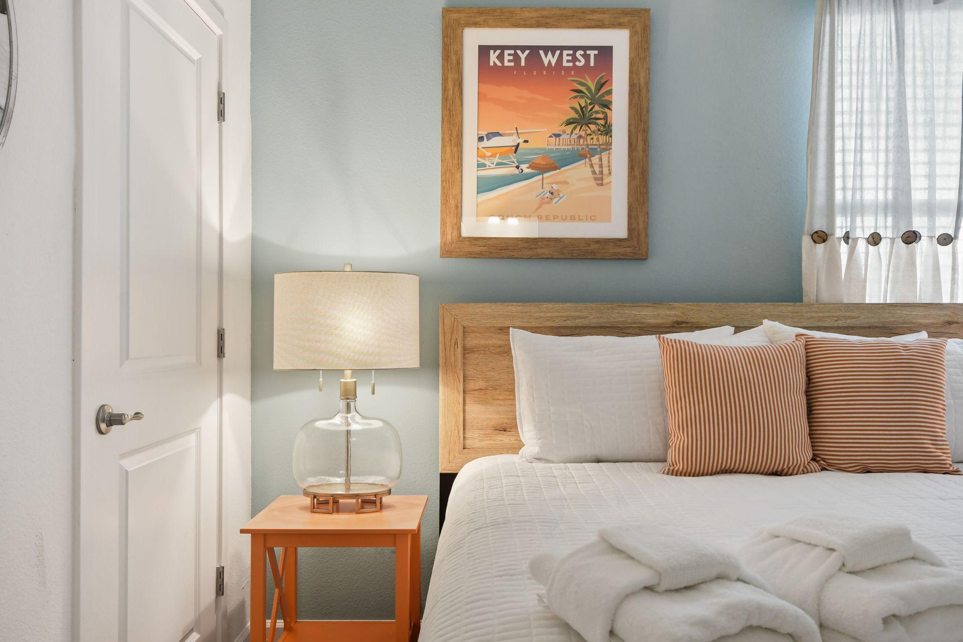This Key West-inspired bedroom has a warm, coastal charm with its soft blue-green accent wall