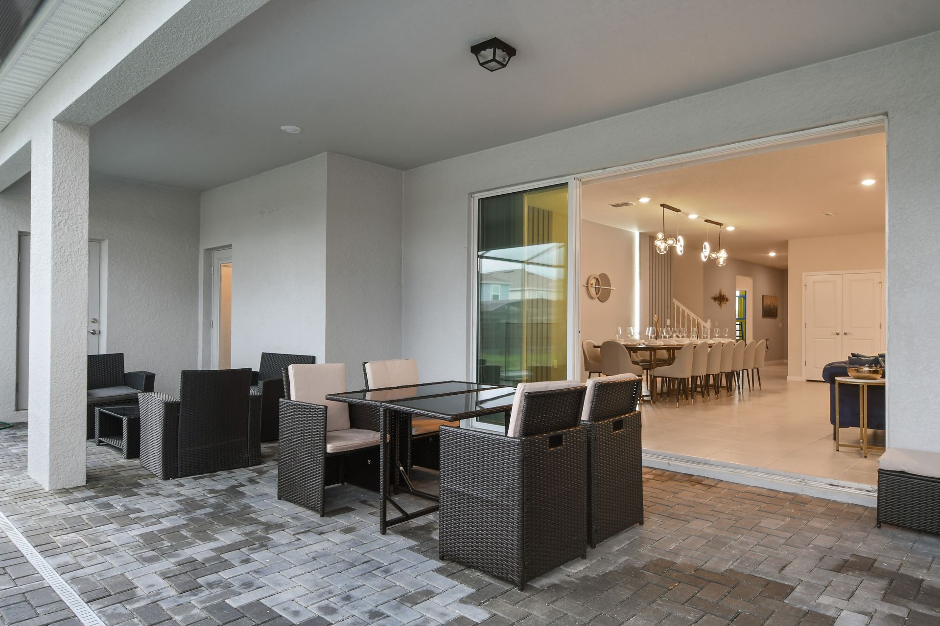 Spacious covered patio with poolside seating, perfect for relaxing or dining.