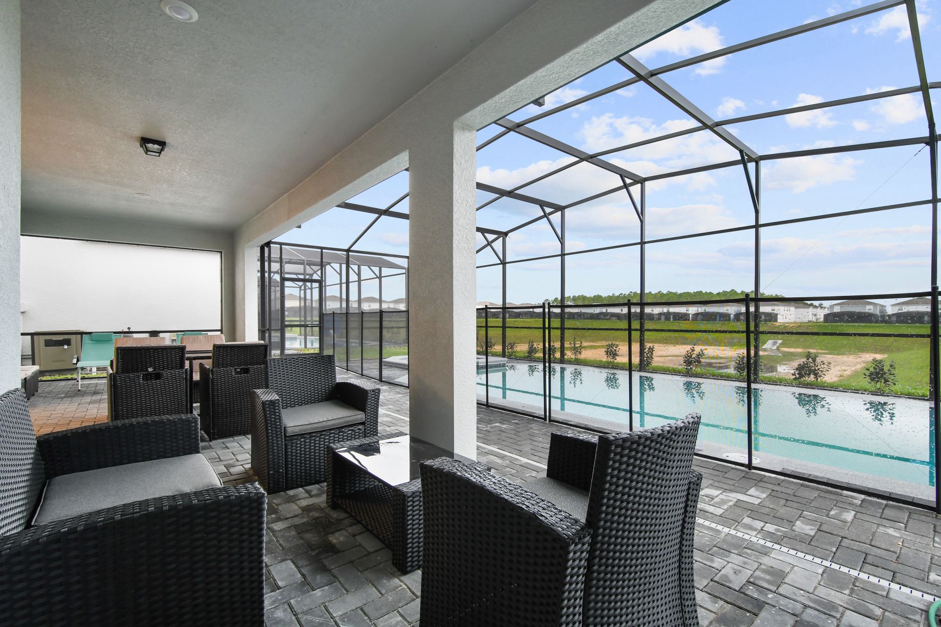 Covered patio with cozy seating and serene poolside views—perfect for unwinding.