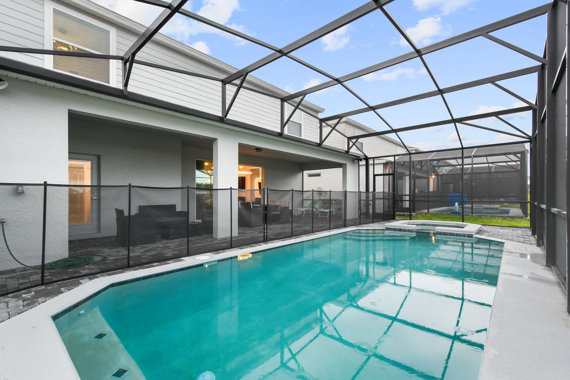 Screened-in pool and spa with spacious patio, perfect for family fun and relaxation.