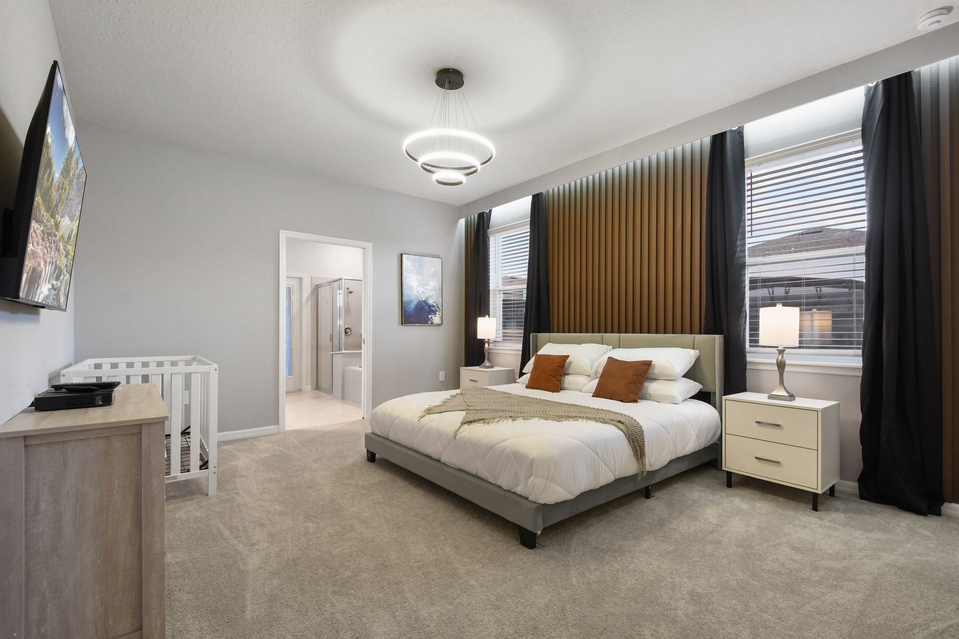 Modern primary suite with warm tones, elegant lighting, and an ensuite bathroom.