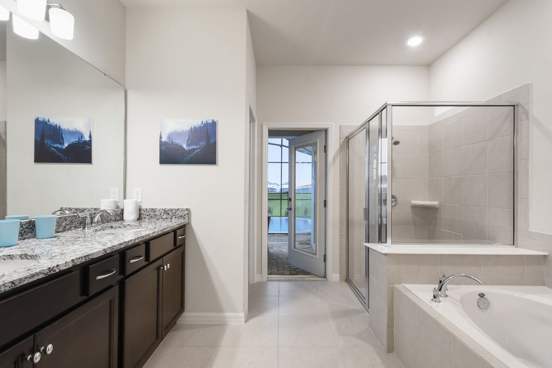 Spa-inspired bath with walk-in shower, dual vanities, and poolside access.